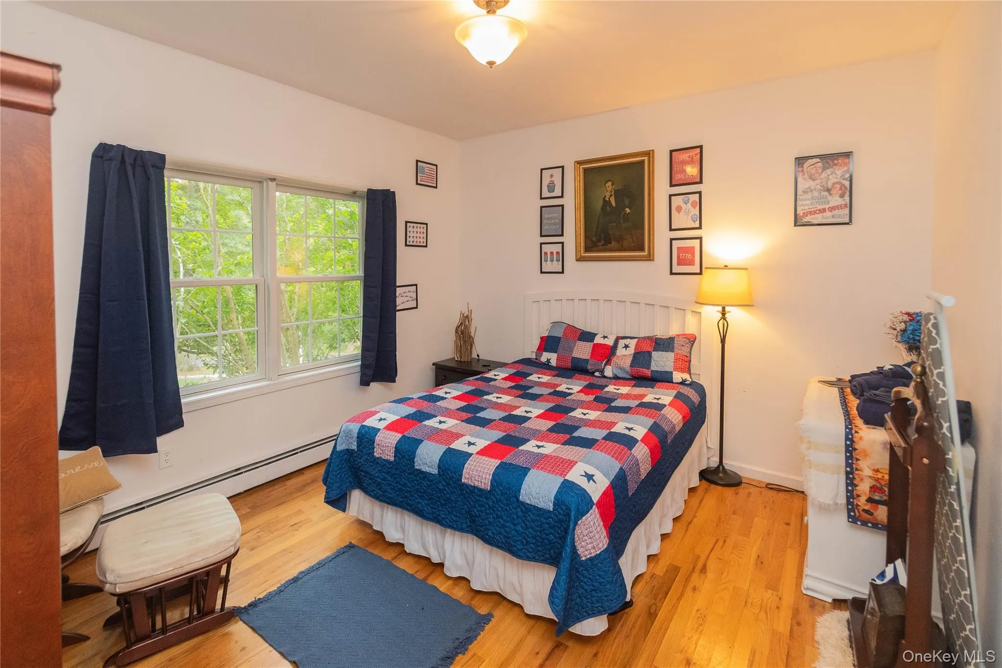 Bedroom featuring light wood finished floors and baseboard heating Bedroom featuring light wood finished floors and baseboard heating