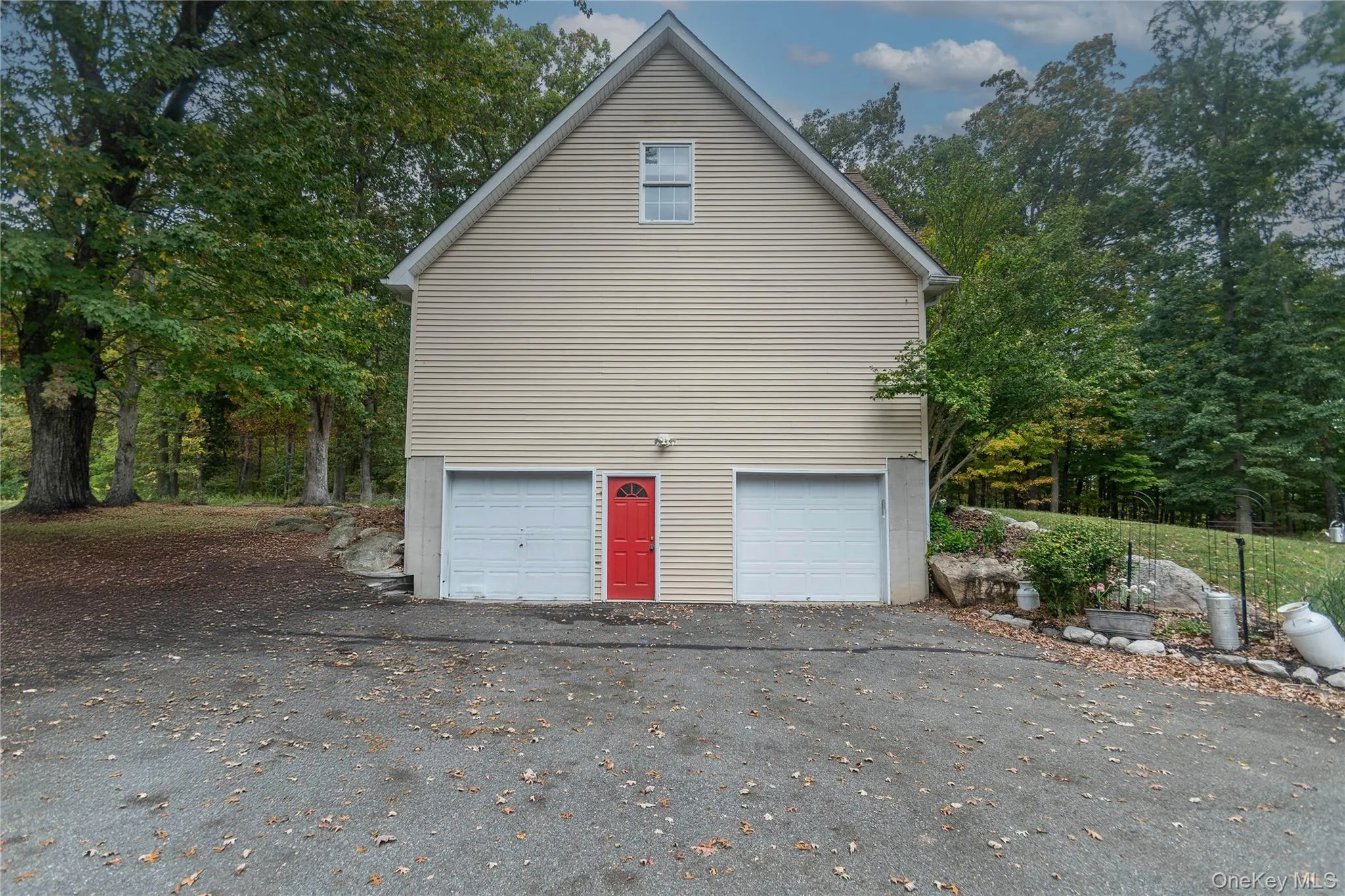 Garage with asphalt driveway and view of wooded area Garage with asphalt driveway and view of wooded area