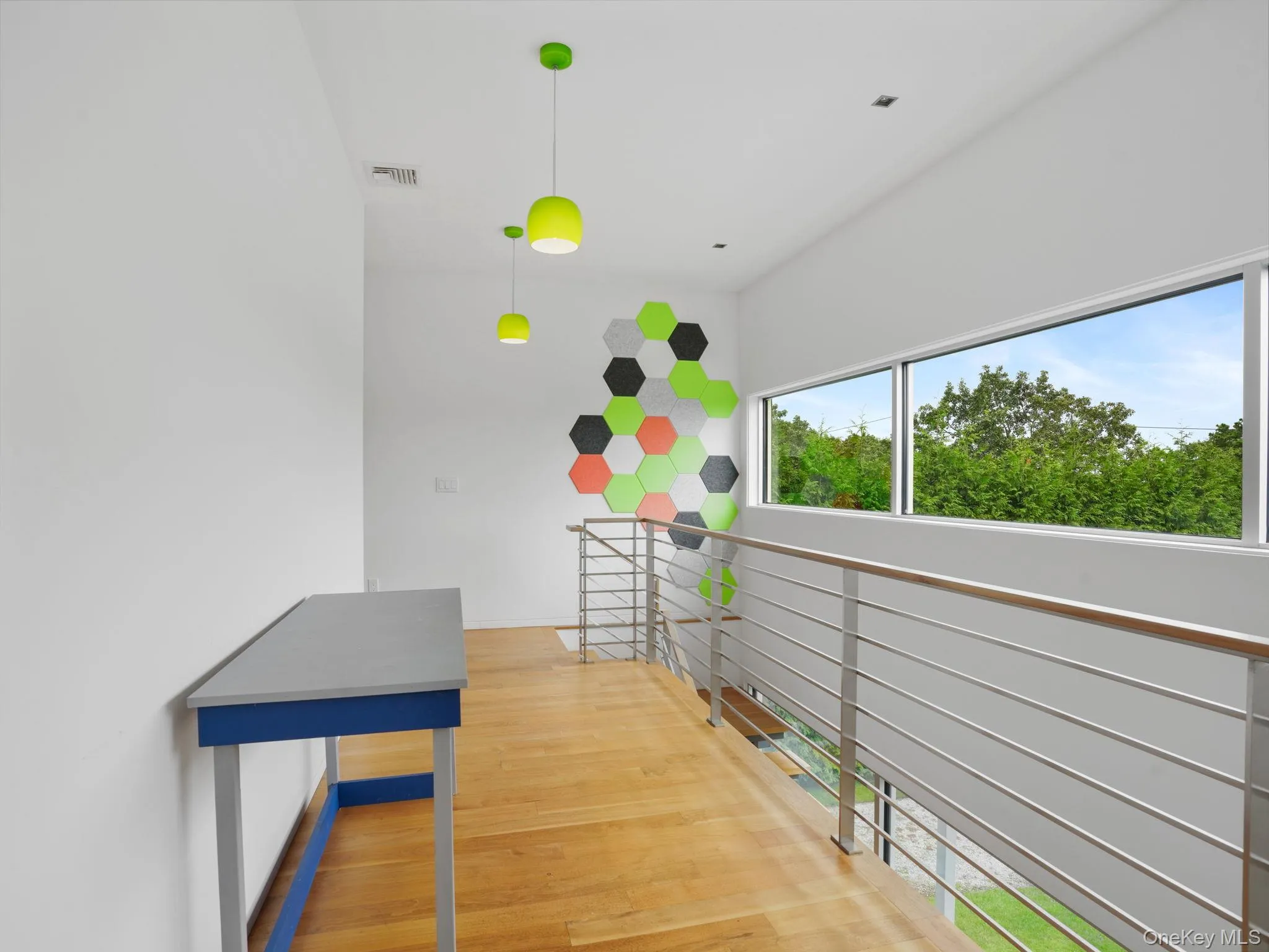 Corridor featuring light wood-style flooring and an upstairs landing Corridor featuring light wood-style flooring and an upstairs landing