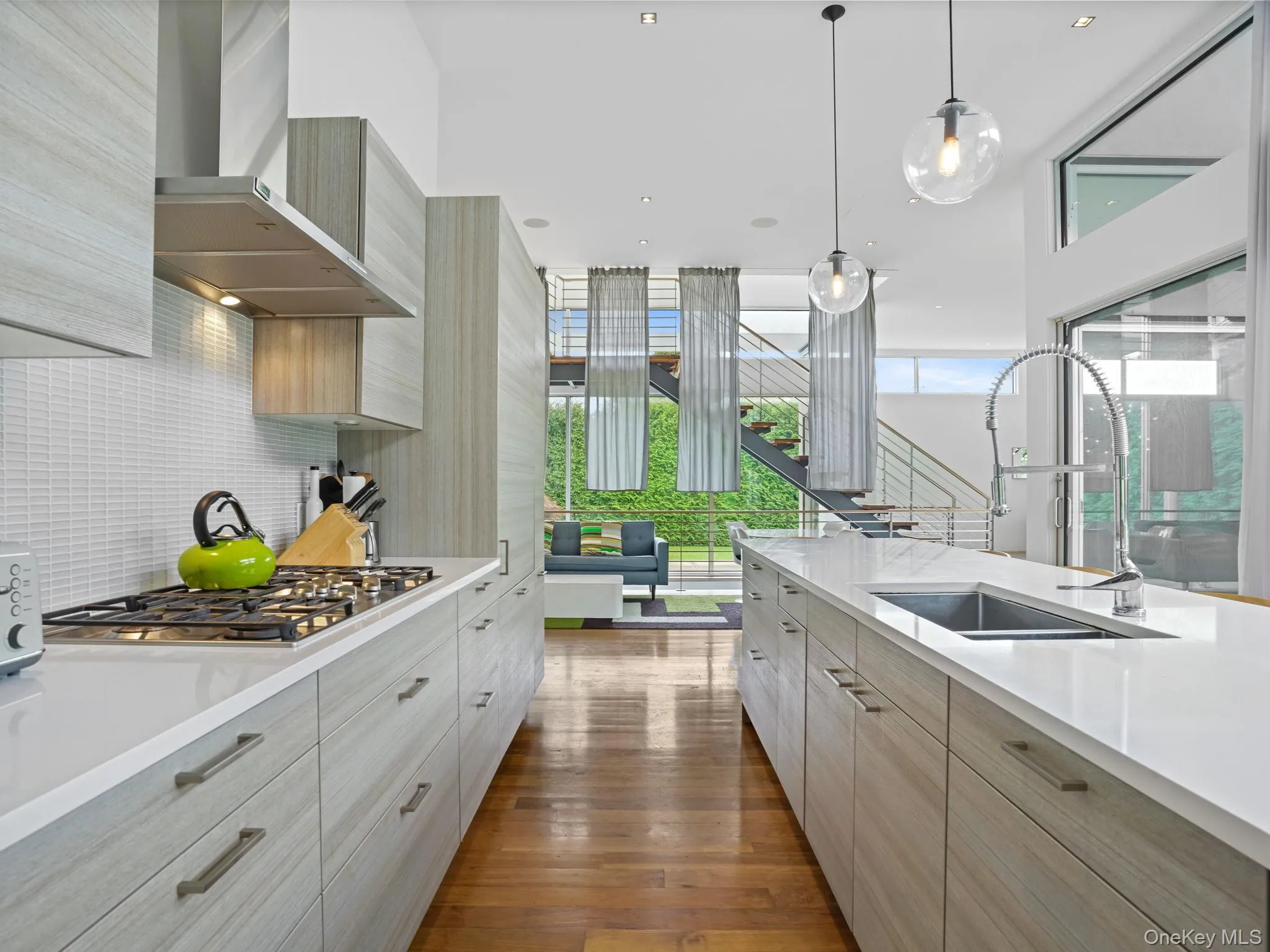 Kitchen with modern cabinets, healthy amount of natural light, decorative backsplash, and recessed lighting Kitchen with modern cabinets, healthy amount of natural light, decorative backsplash, and recessed lighting