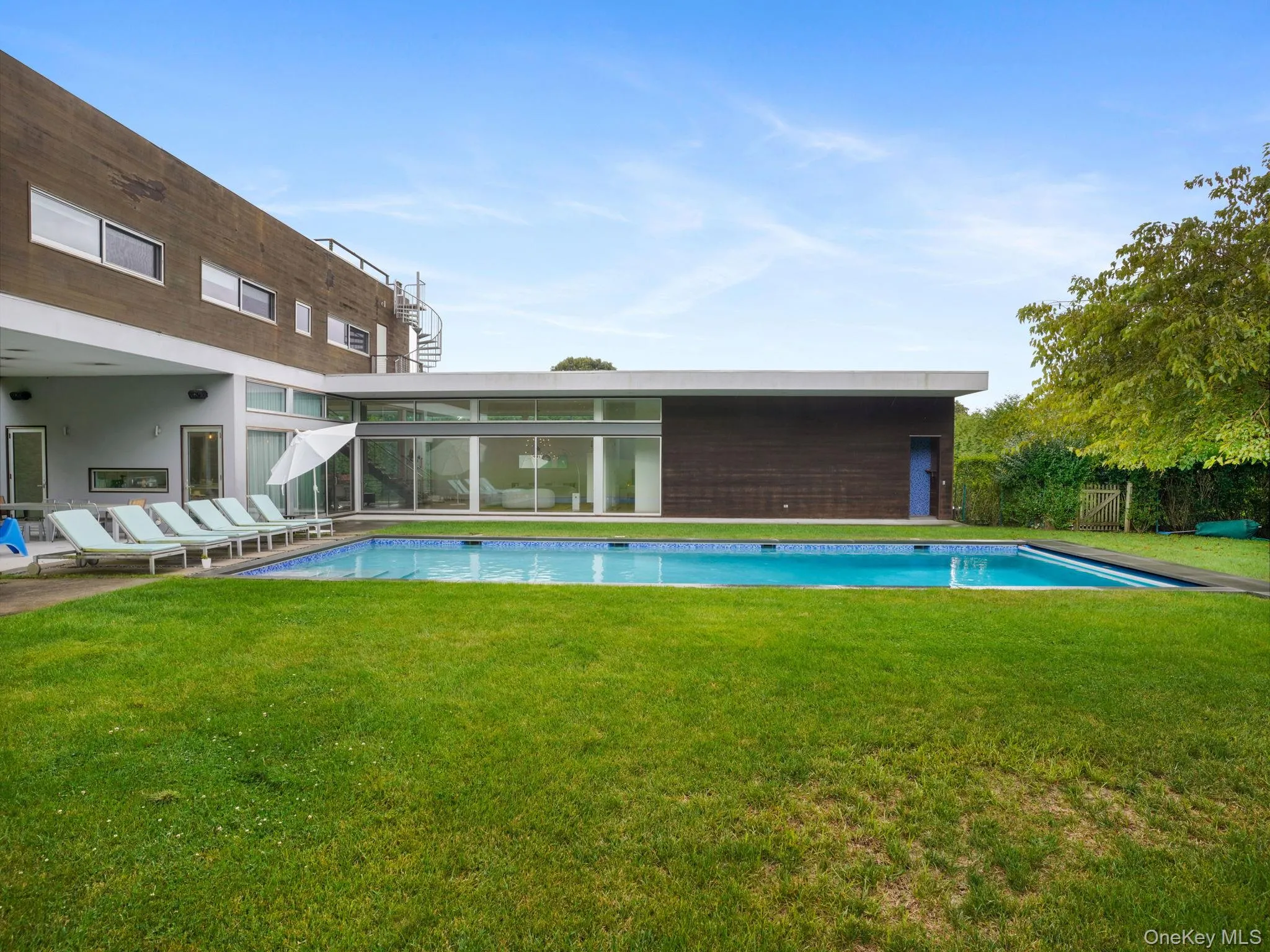 Swimming pool featuring a patio and a lawn Swimming pool featuring a patio and a lawn