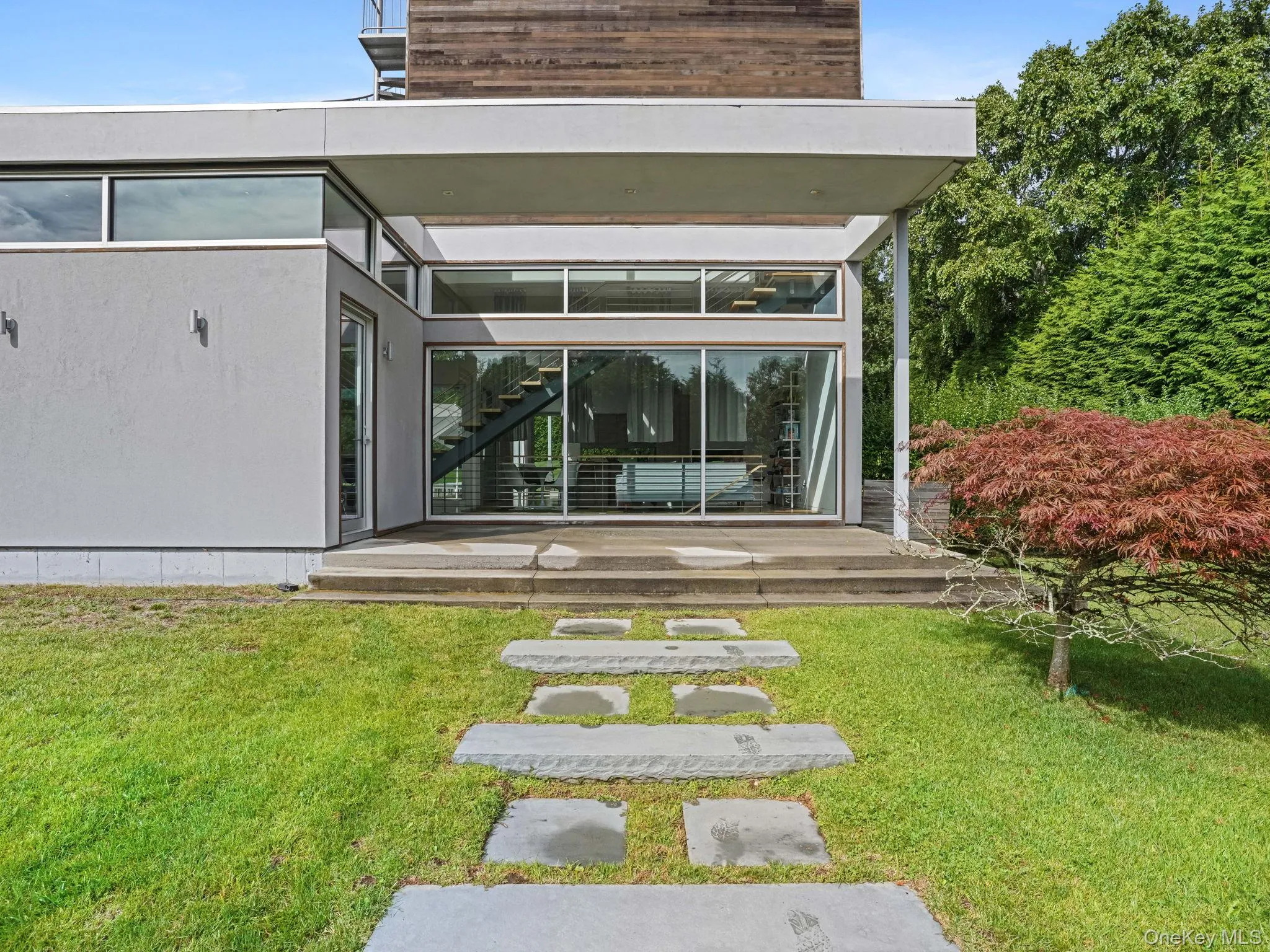 View of exterior entry featuring a deck and a yard View of exterior entry featuring a deck and a yard
