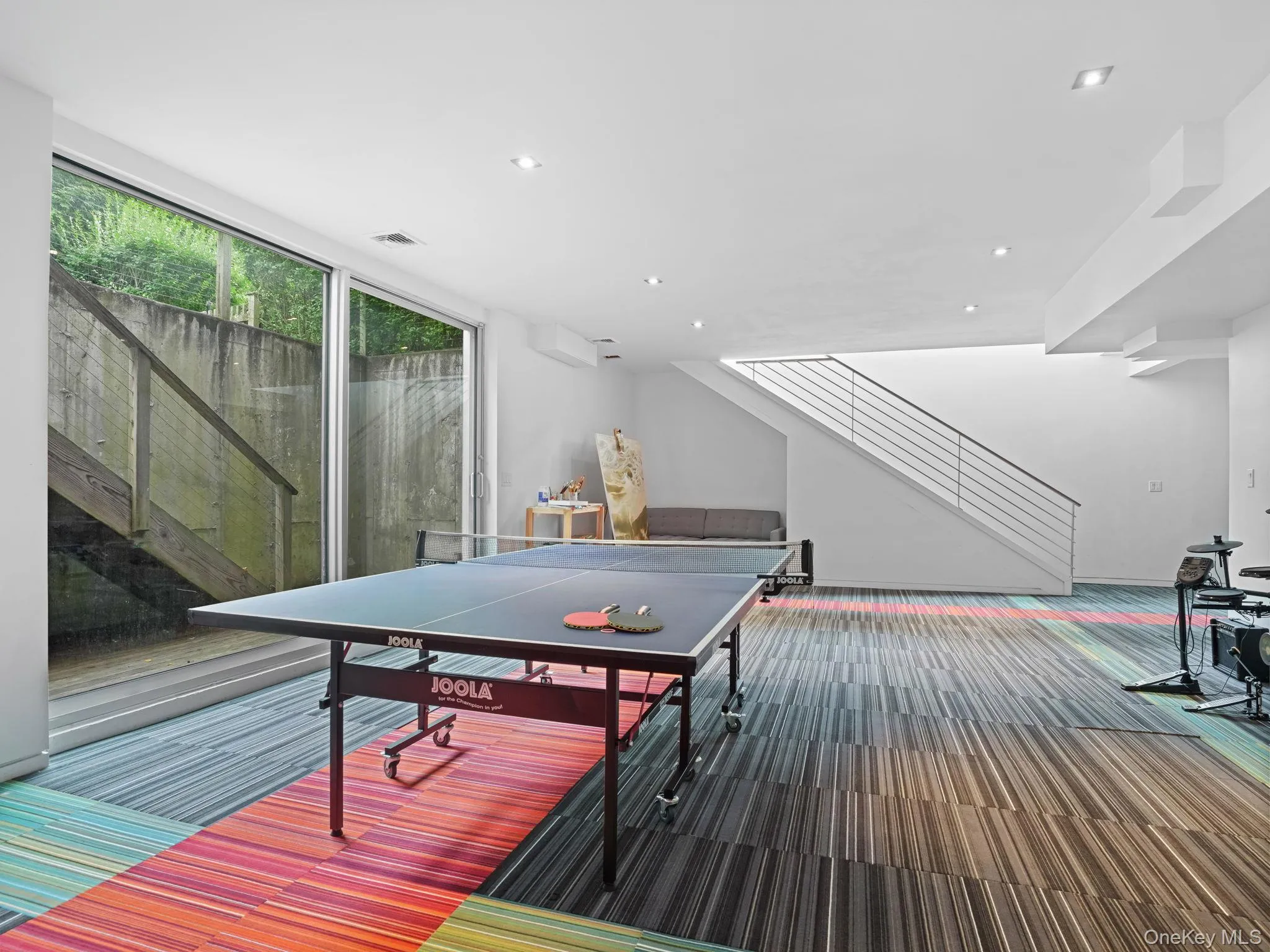 Recreation room featuring carpet, recessed lighting, and a wall of windows Recreation room featuring carpet, recessed lighting, and a wall of windows