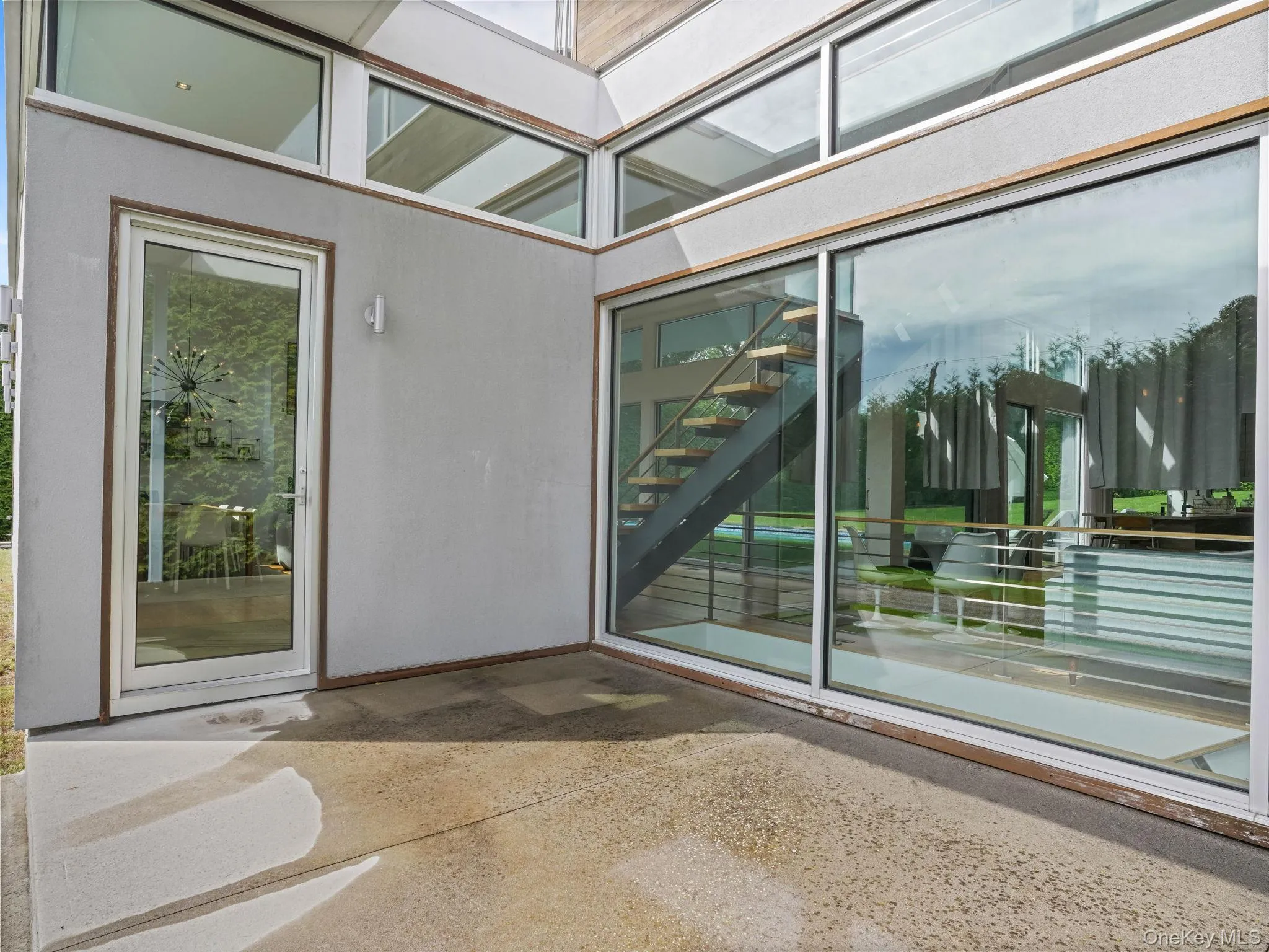 Entrance to property with stucco siding and a patio area Entrance to property with stucco siding and a patio area