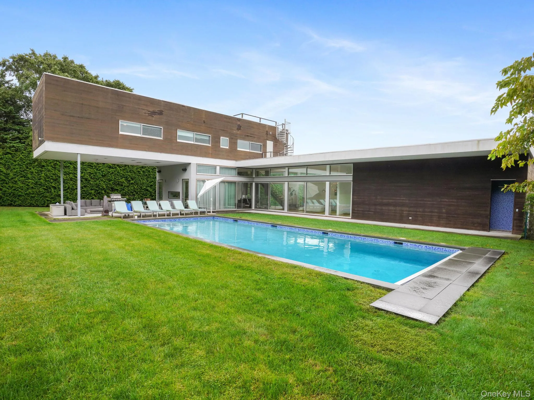 Swimming pool featuring a patio, a lawn, and a sunroom Swimming pool featuring a patio, a lawn, and a sunroom