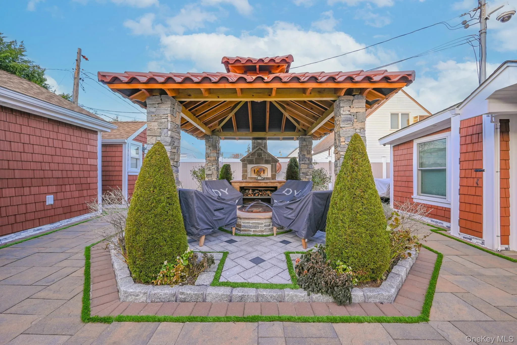 View of patio featuring a gazebo, an outdoor stone fireplace, and area for grilling View of patio featuring a gazebo, an outdoor stone fireplace, and area for grilling