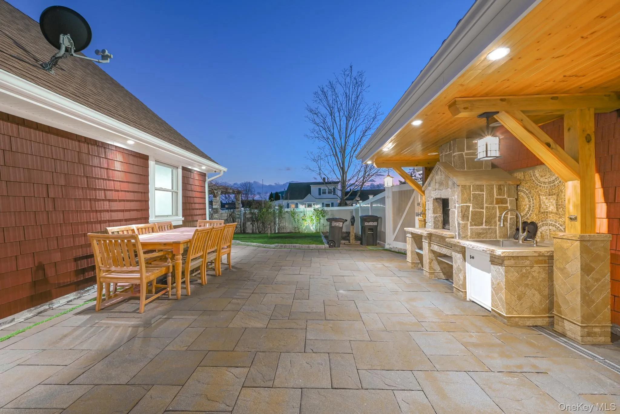 Fenced backyard featuring a patio, an outdoor kitchen, and outdoor dining area Fenced backyard featuring a patio, an outdoor kitchen, and outdoor dining area