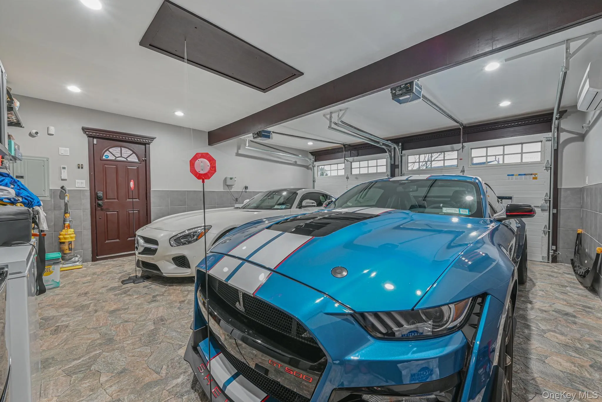 Garage featuring a wainscoted wall, recessed lighting, and a garage door opener Garage featuring a wainscoted wall, recessed lighting, and a garage door opener