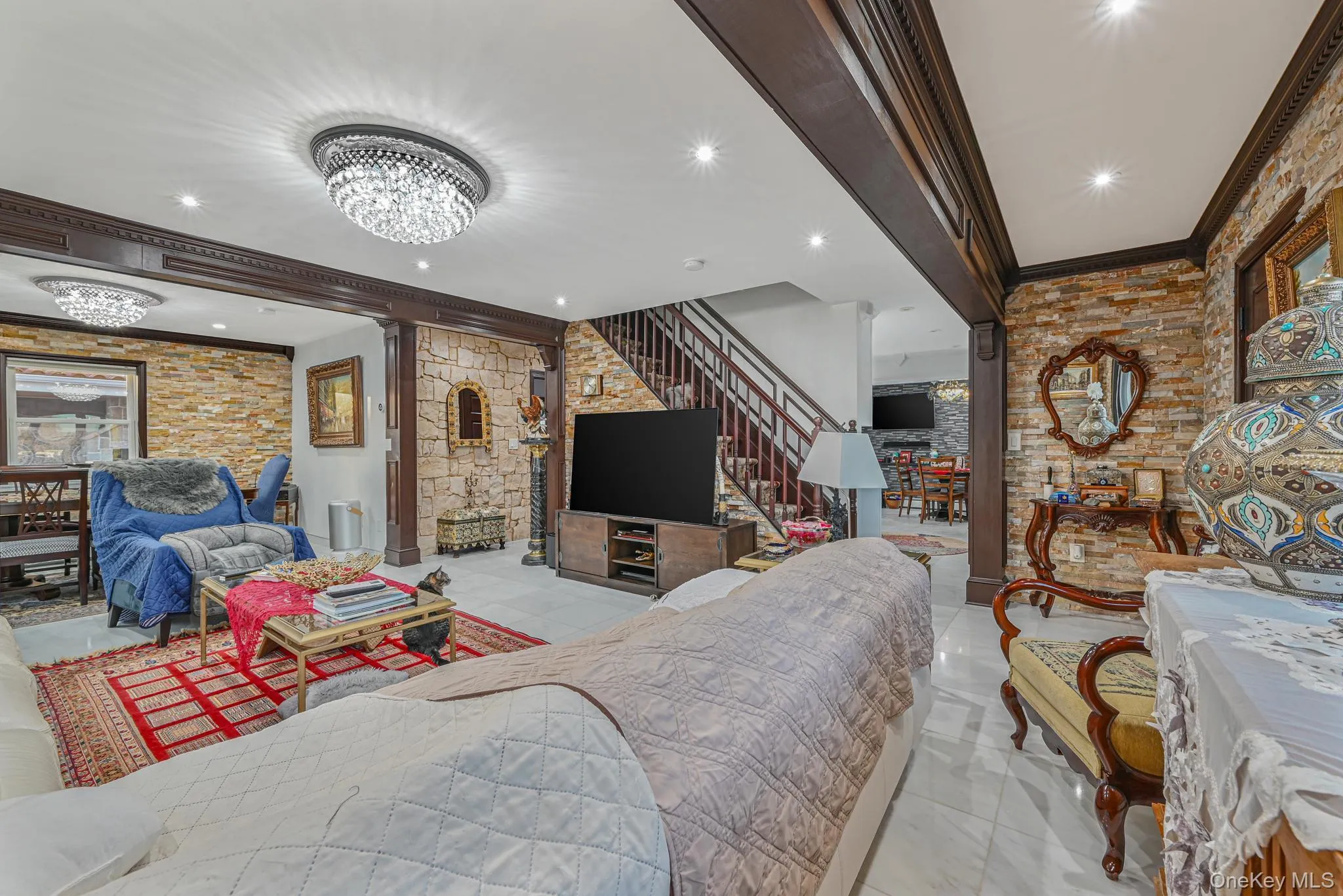 Living room featuring ornamental molding, a chandelier, recessed lighting, light tile patterned flooring, and stairs Living room featuring ornamental molding, a chandelier, recessed lighting, light tile patterned flooring, and stairs