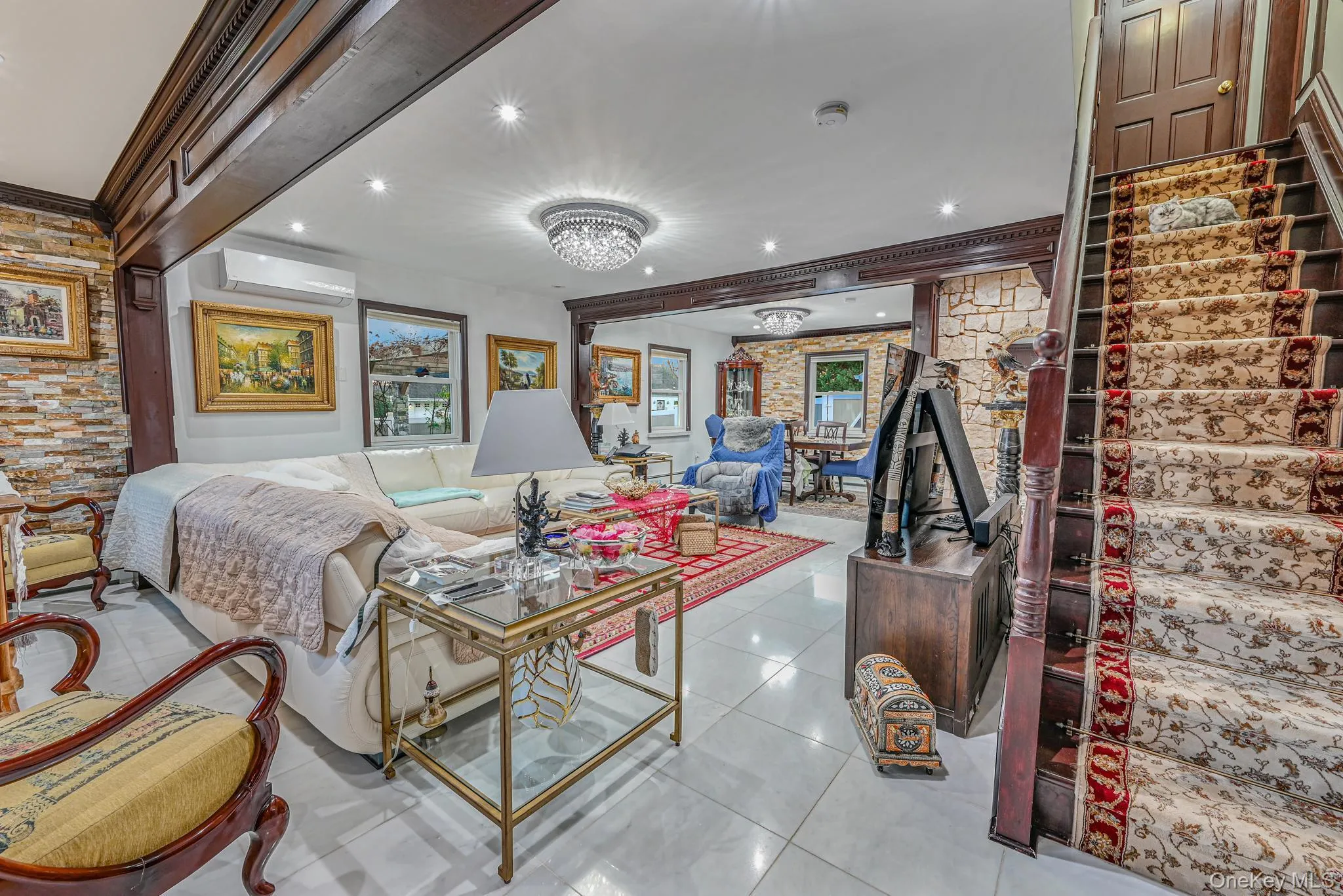 Living area featuring ornamental molding, light tile patterned floors, a chandelier, an AC wall unit, and recessed lighting Living area featuring ornamental molding, light tile patterned floors, a chandelier, an AC wall unit, and recessed lighting