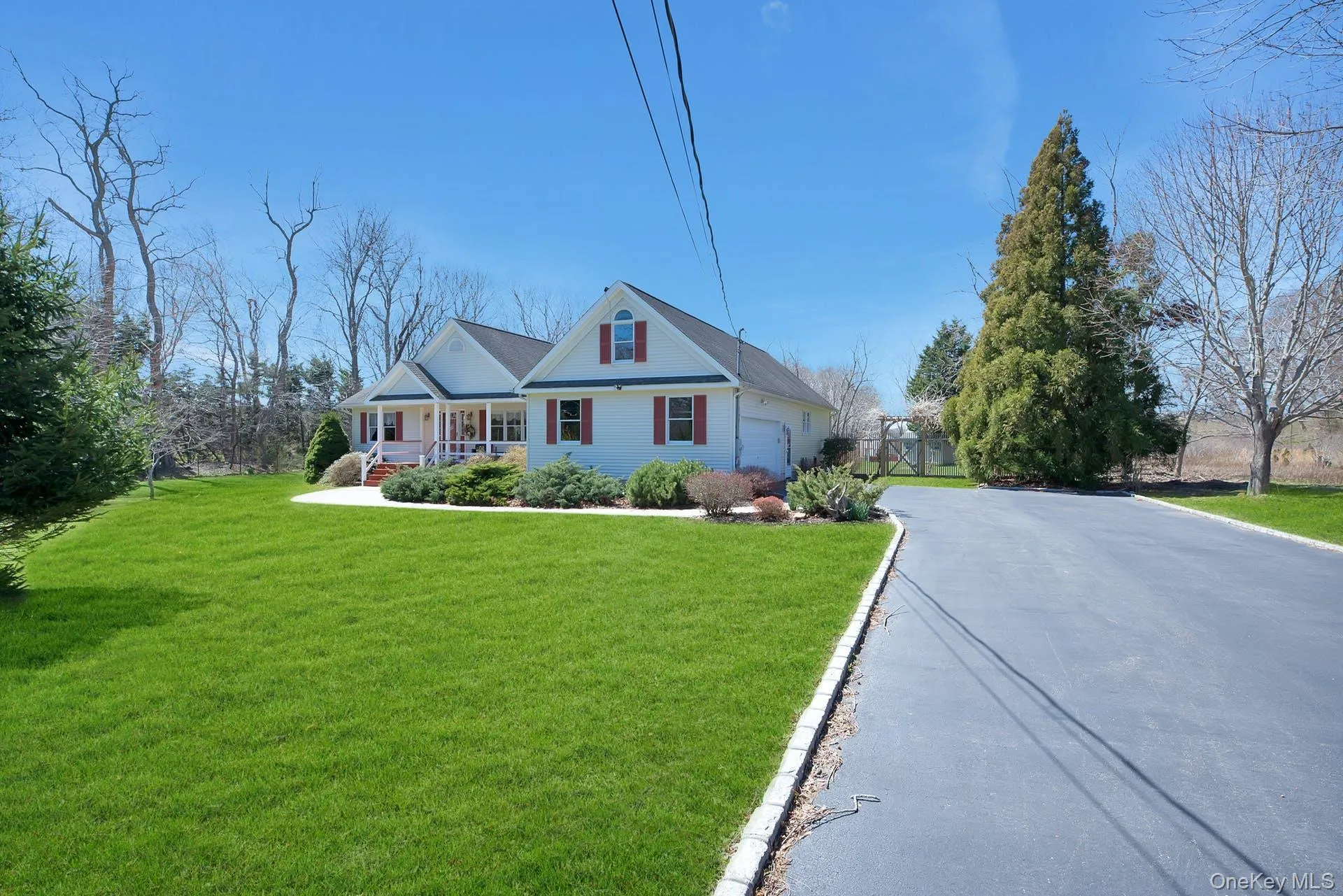 View of front of home with a front yard, covered porch, a garage, and driveway View of front of home with a front yard, covered porch, a garage, and driveway