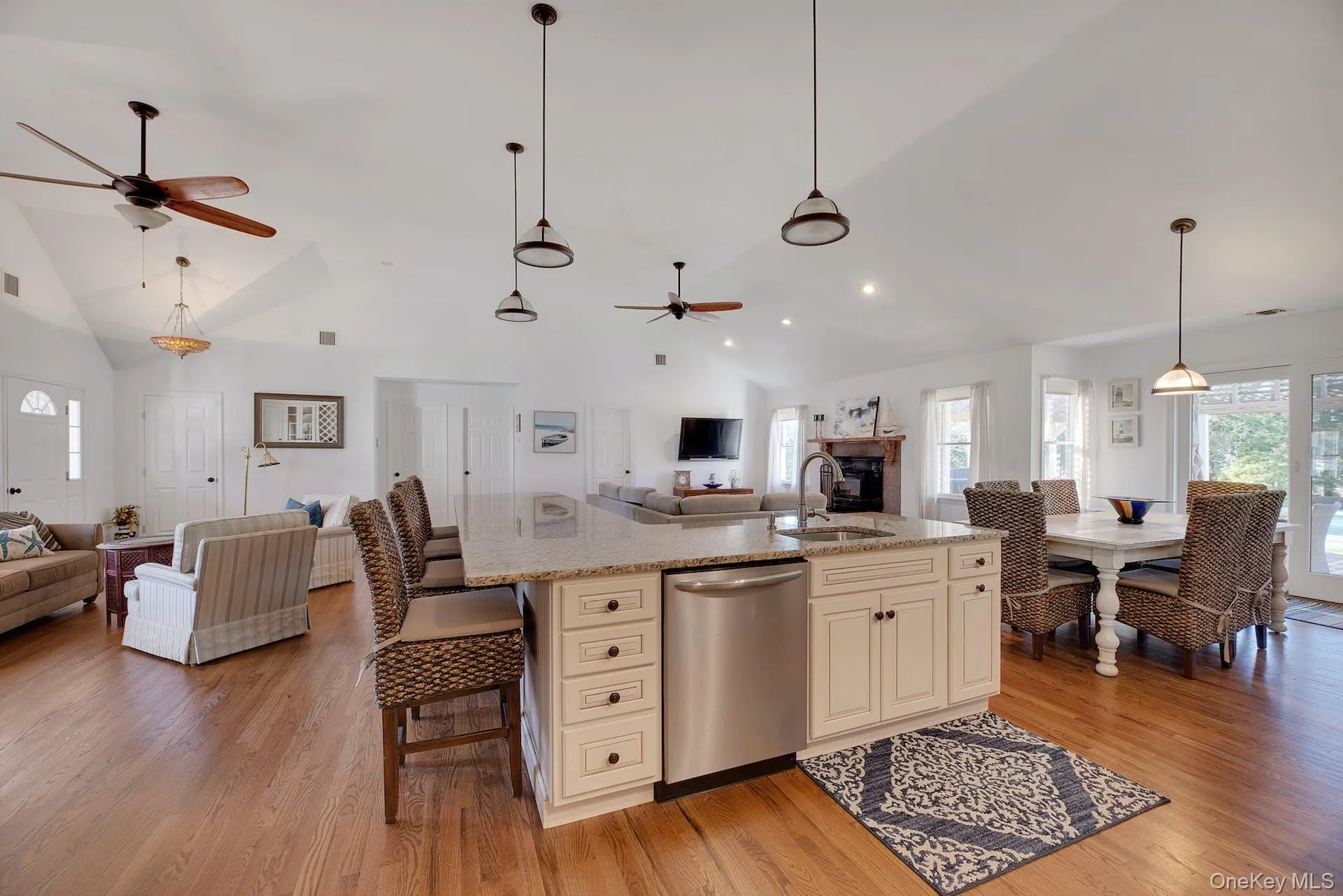 Kitchen featuring open floor plan, dishwasher, decorative light fixtures, ceiling fan, and light wood-style flooring Kitchen featuring open floor plan, dishwasher, decorative light fixtures, ceiling fan, and light wood-style flooring