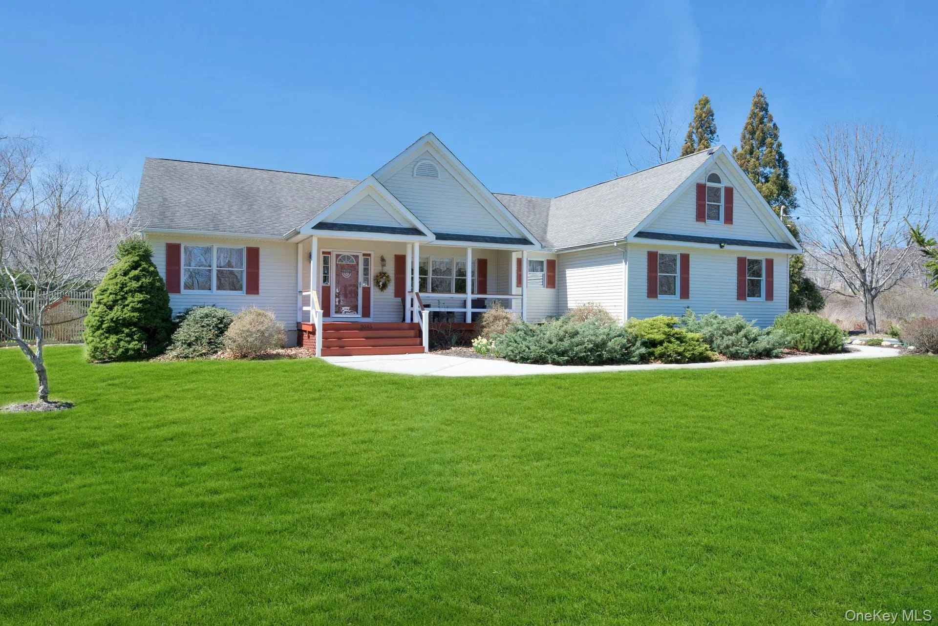View of front facade featuring a porch, a front yard, and roof with shingles View of front facade featuring a porch, a front yard, and roof with shingles