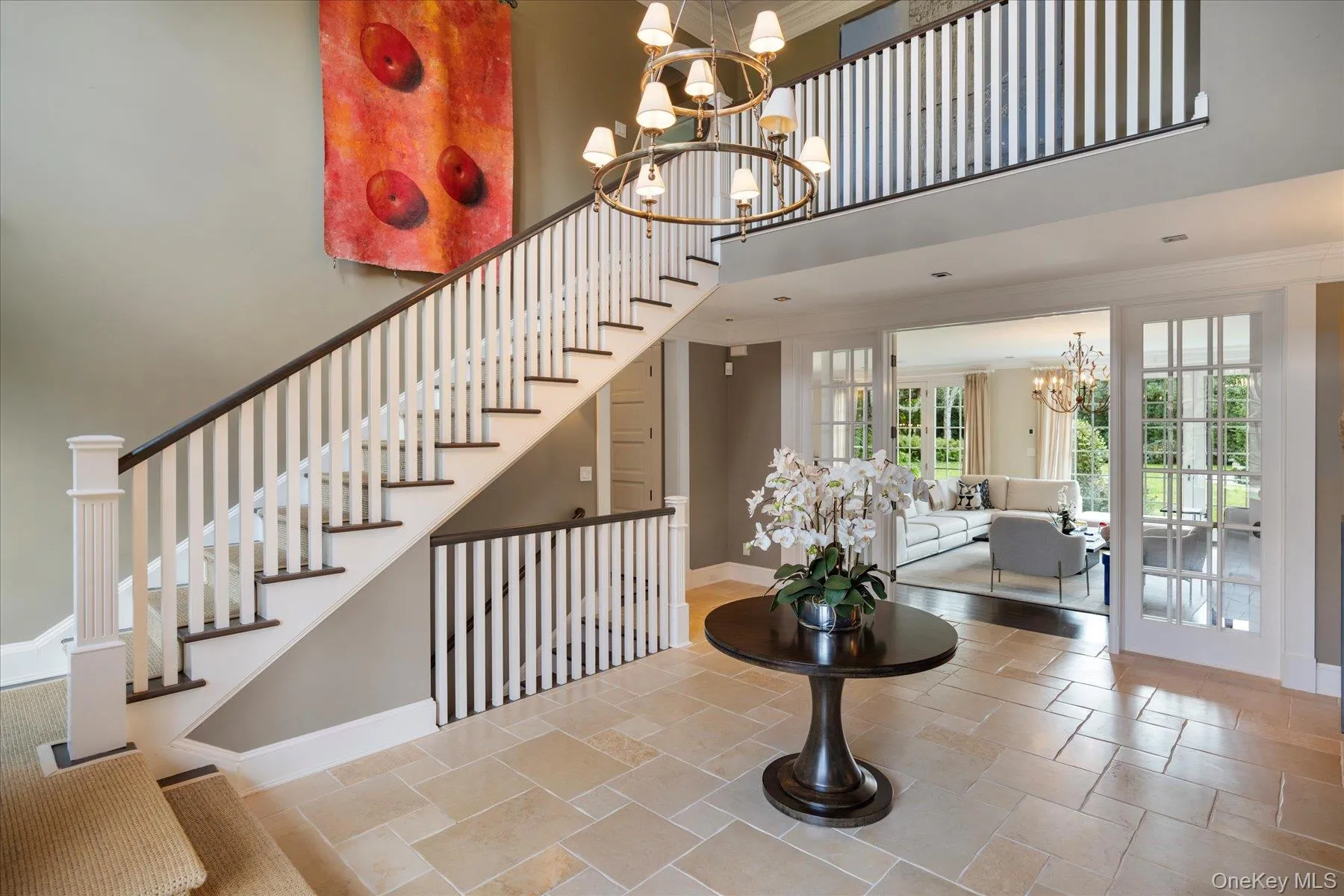 Stairs with a chandelier, a towering ceiling, crown molding, and stone tile flooring Stairs with a chandelier, a towering ceiling, crown molding, and stone tile flooring