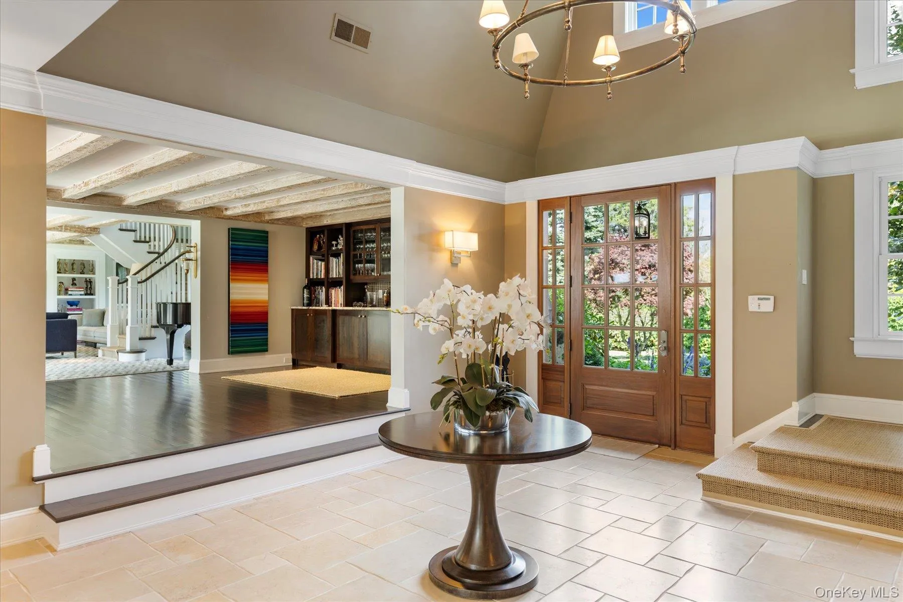 Entrance foyer featuring stairs, beamed ceiling, and a chandelier Entrance foyer featuring stairs, beamed ceiling, and a chandelier