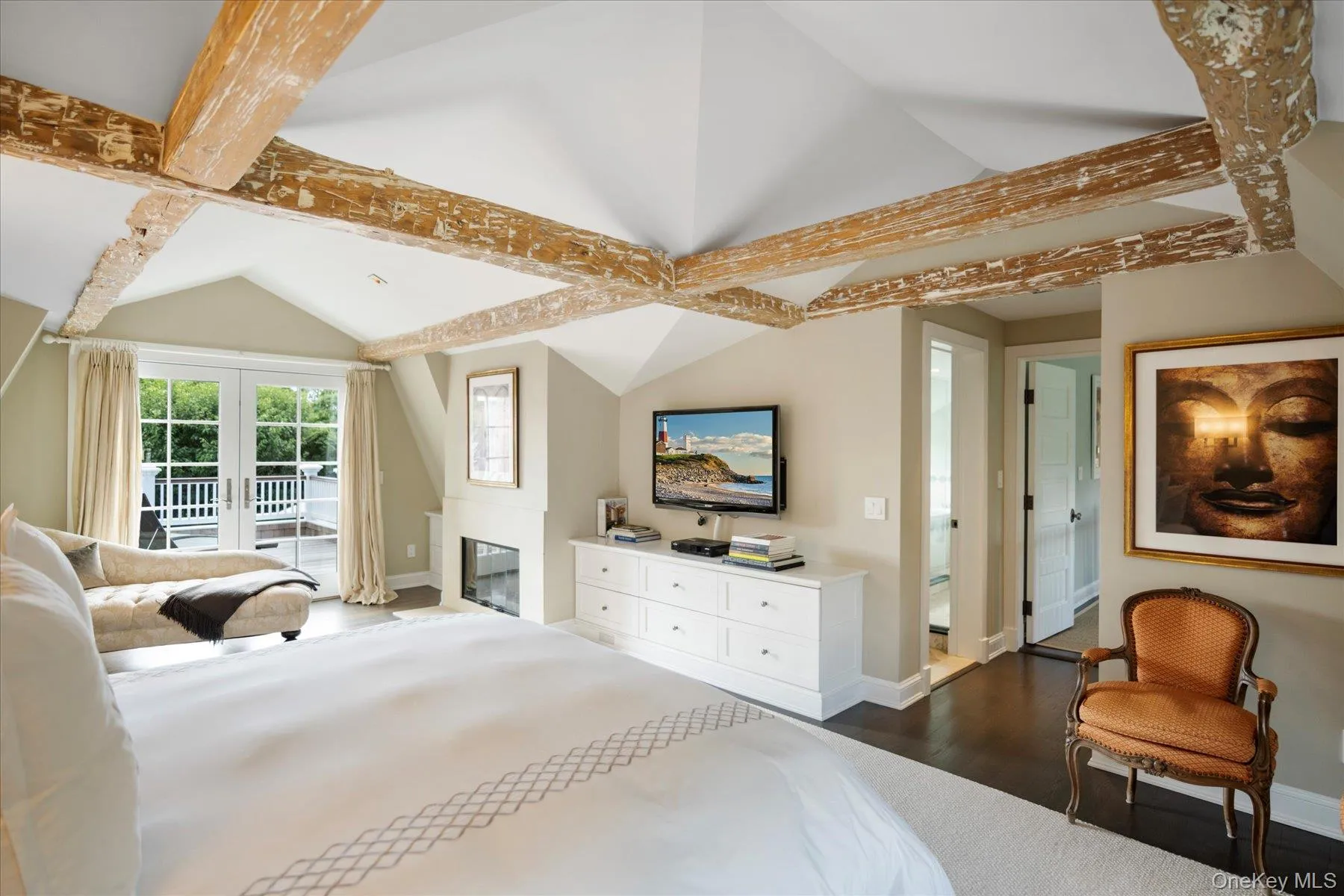 Bedroom featuring dark wood finished floors, a glass covered fireplace, and access to outside Bedroom featuring dark wood finished floors, a glass covered fireplace, and access to outside
