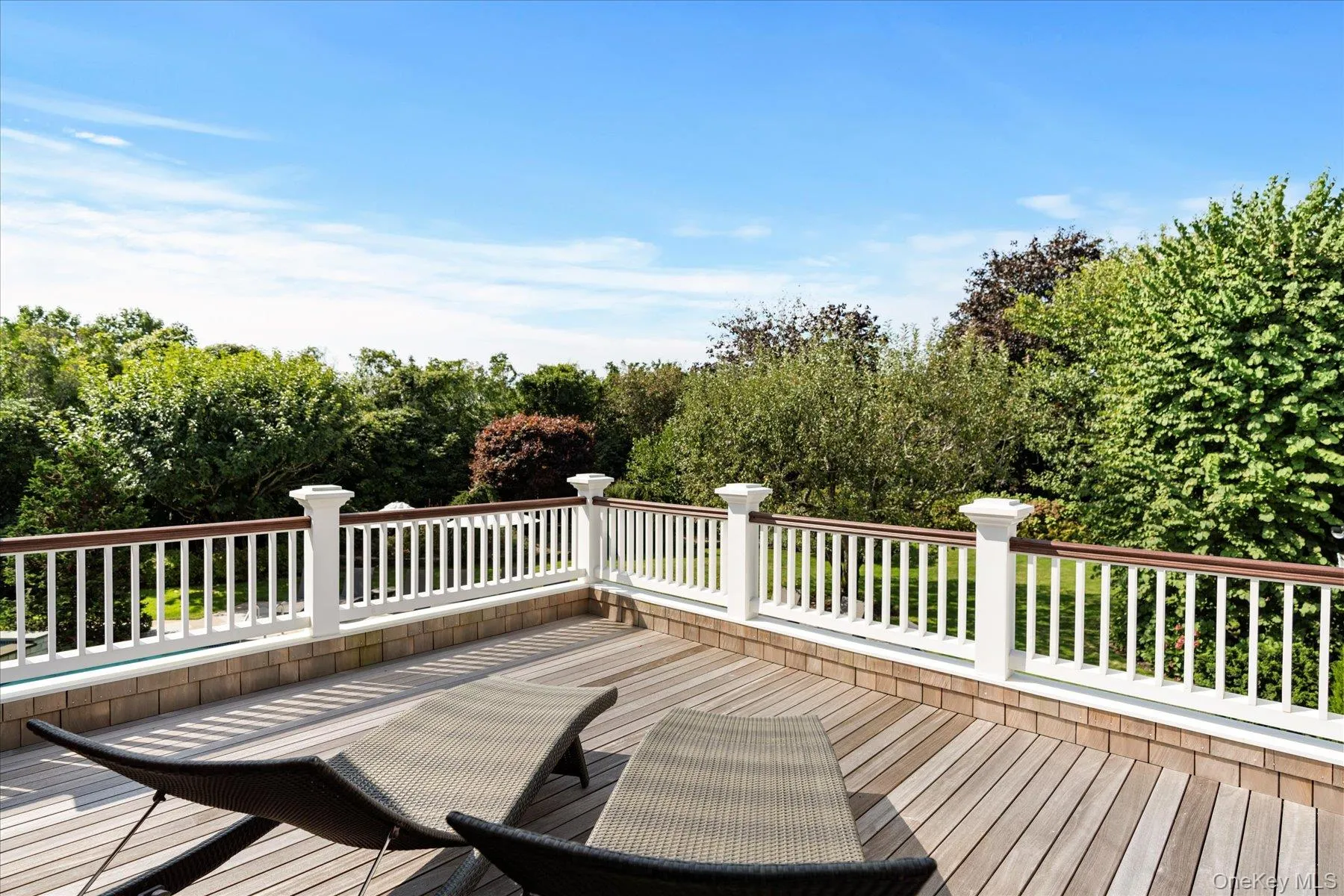 Wooden terrace featuring view of wooded area Wooden terrace featuring view of wooded area