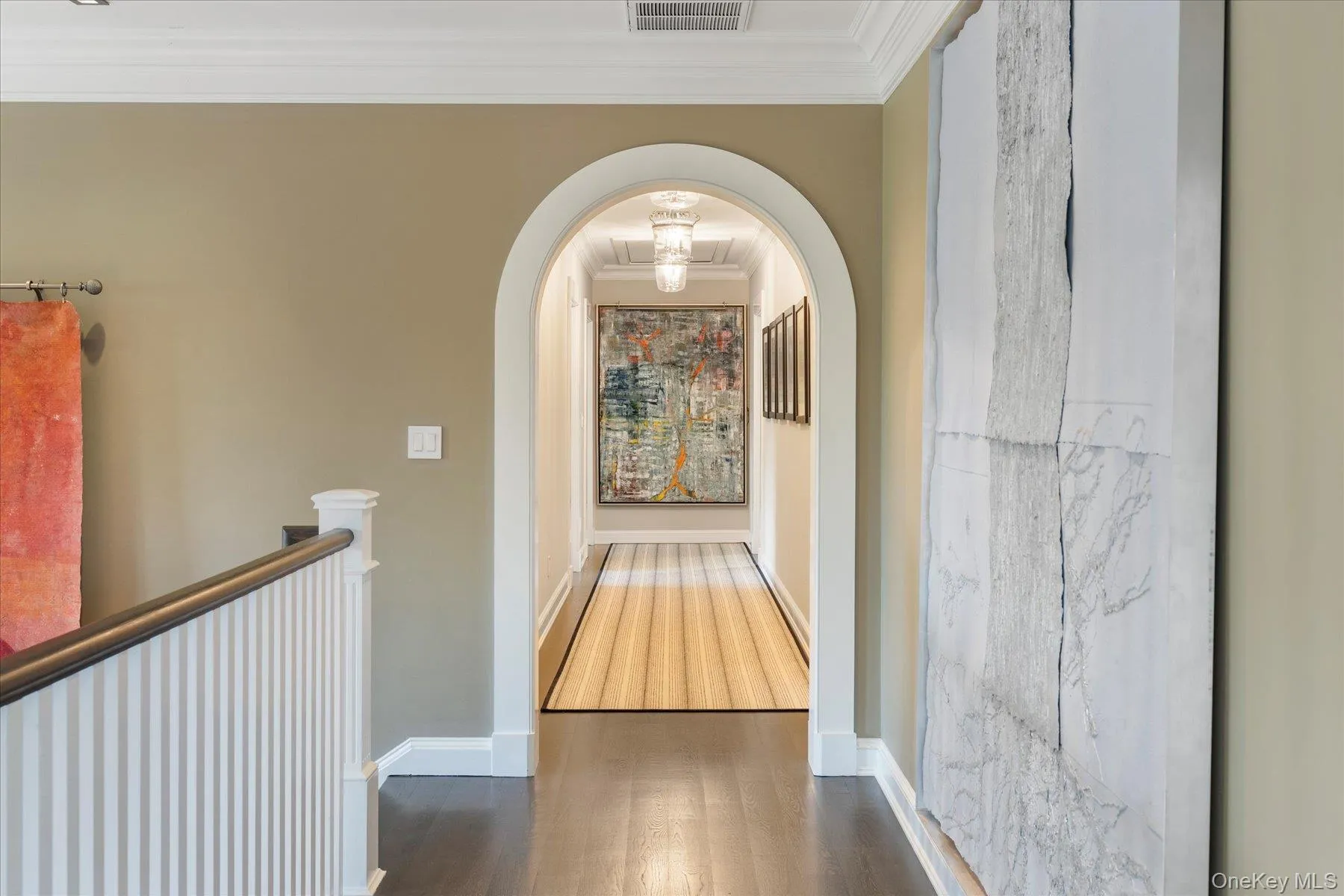 Hall featuring crown molding, dark wood-type flooring, and arched walkways Hall featuring crown molding, dark wood-type flooring, and arched walkways