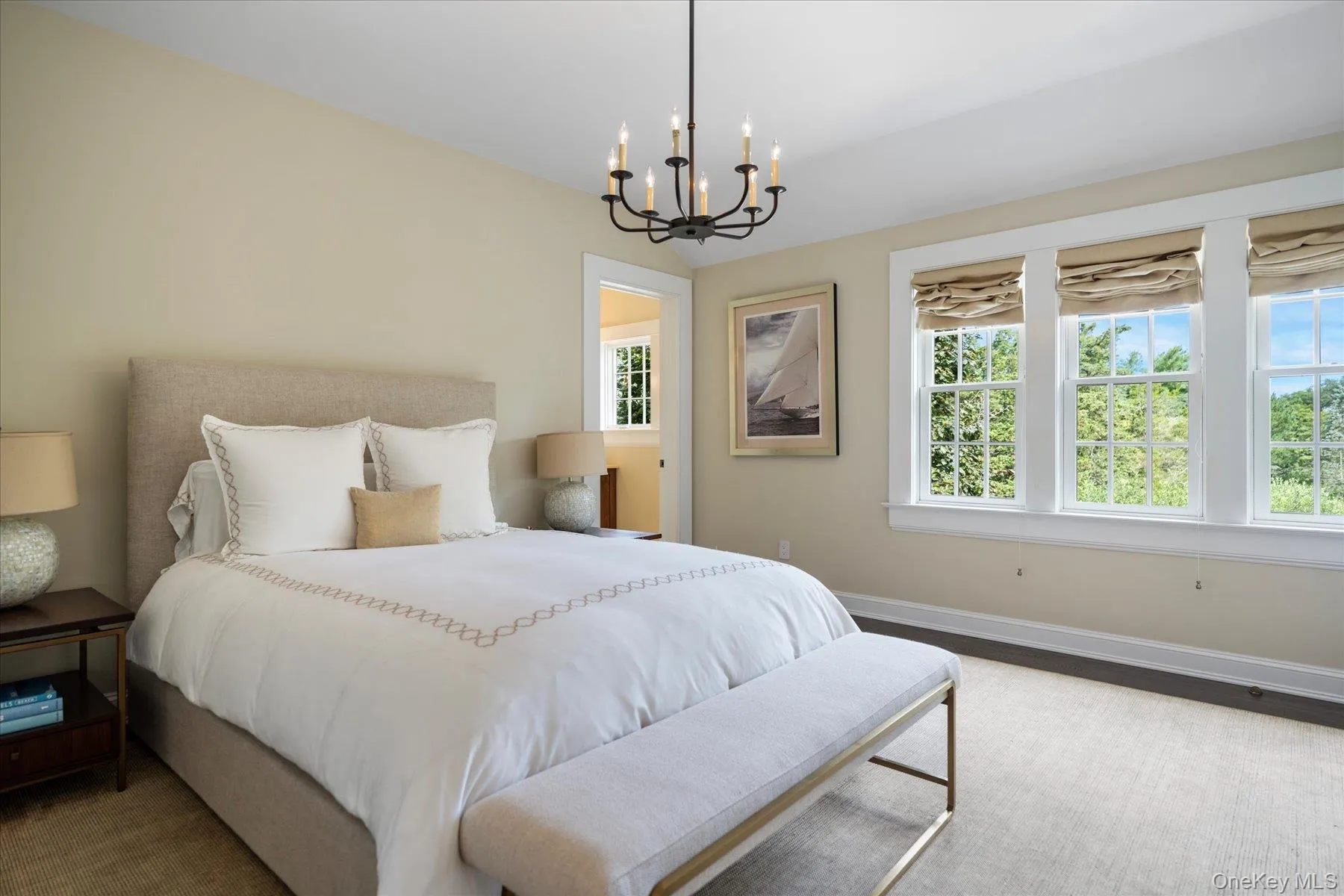 Bedroom featuring multiple windows, a chandelier, and wood finished floors Bedroom featuring multiple windows, a chandelier, and wood finished floors