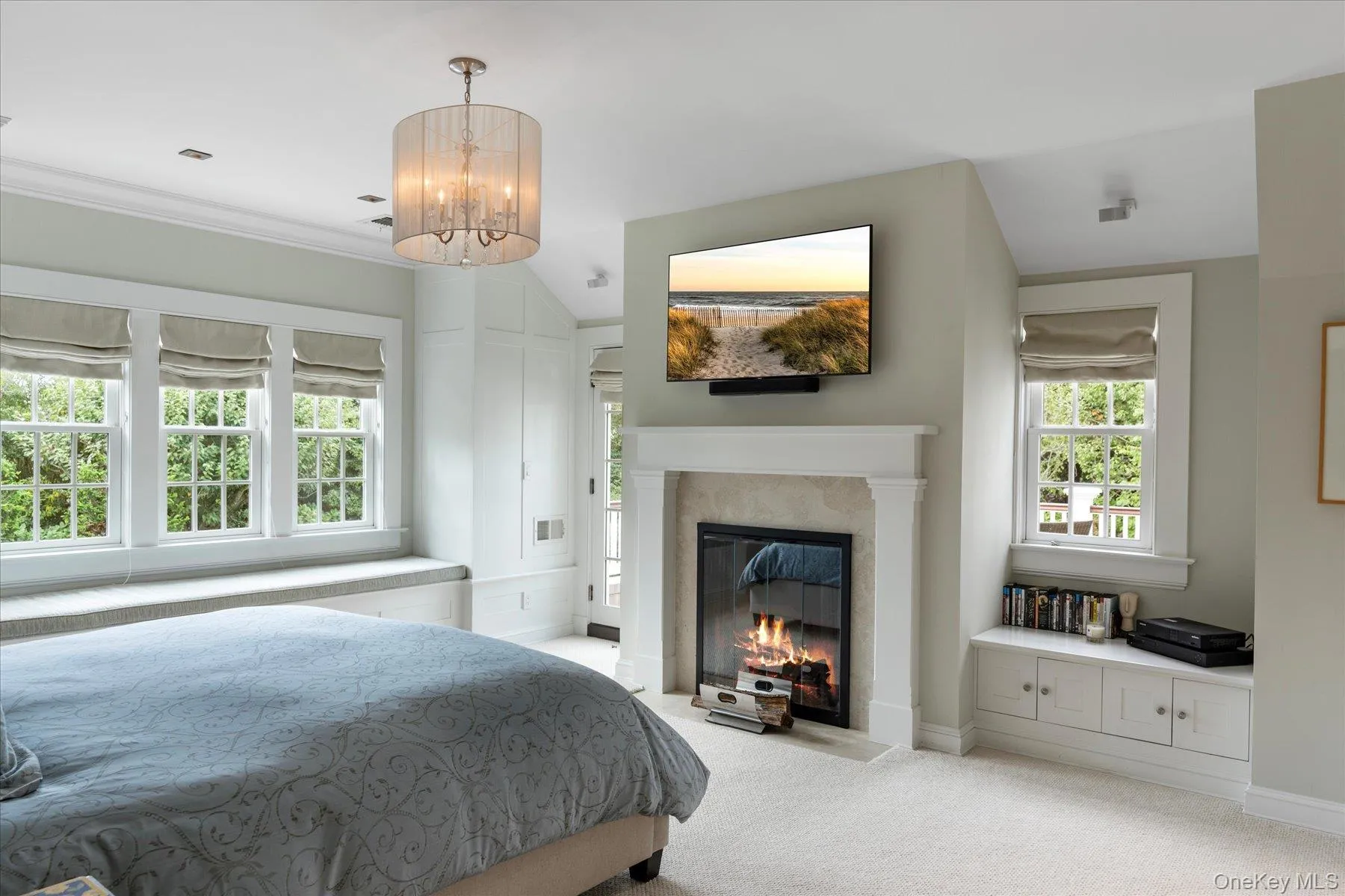 Bedroom featuring carpet flooring, a premium fireplace, and ornamental molding Bedroom featuring carpet flooring, a premium fireplace, and ornamental molding