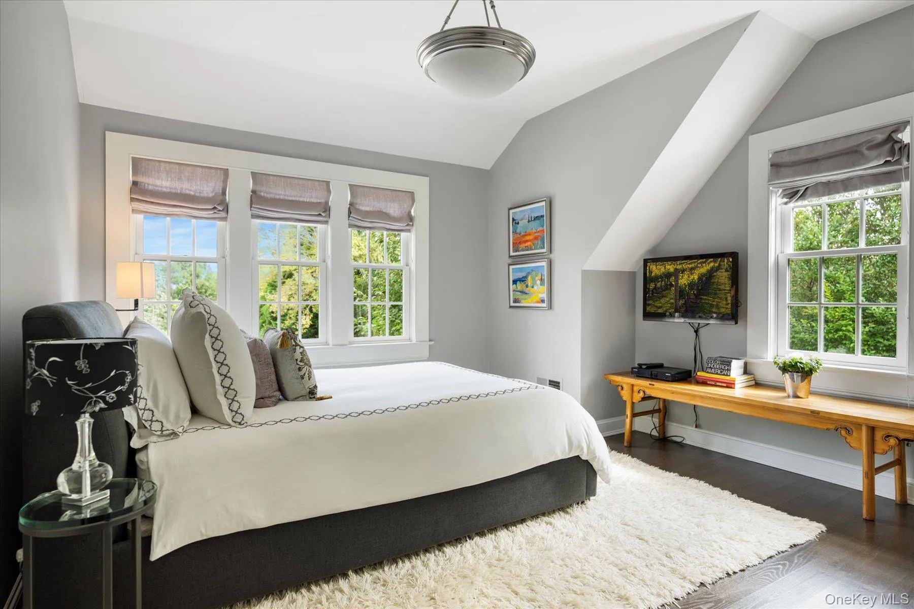 Bedroom featuring dark wood-style flooring and vaulted ceiling Bedroom featuring dark wood-style flooring and vaulted ceiling