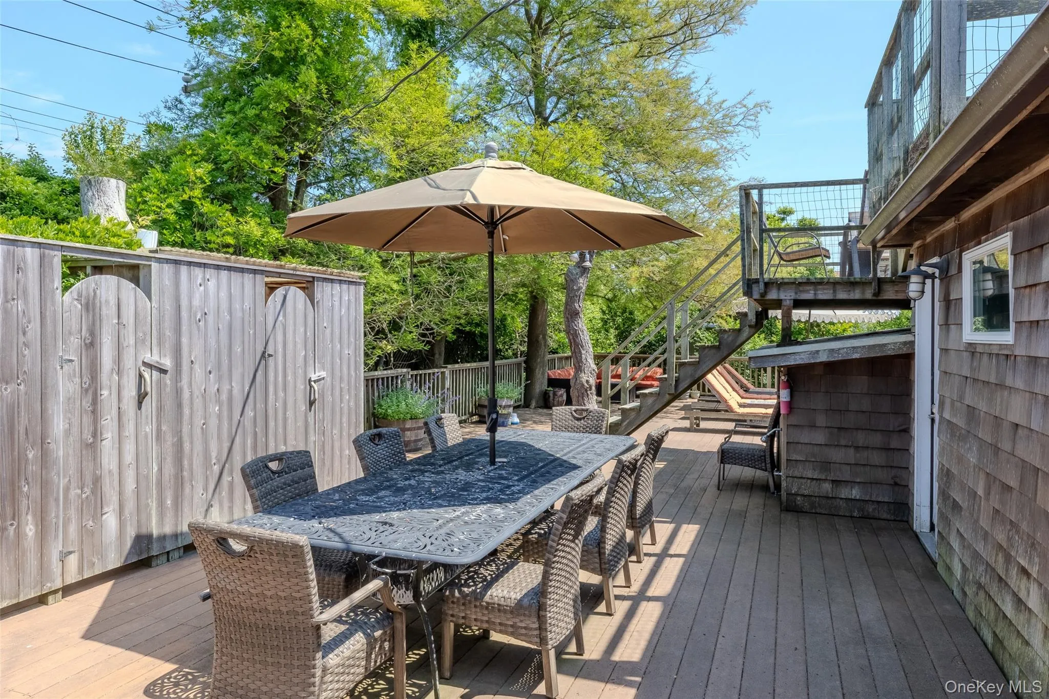 Wooden terrace featuring stairs and outdoor dining area Wooden terrace featuring stairs and outdoor dining area