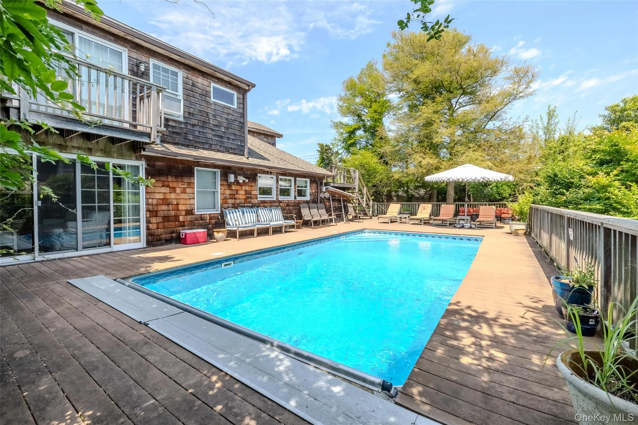 View of swimming pool with a wooden deck, a balcony, and a patio area View of swimming pool with a wooden deck, a balcony, and a patio area