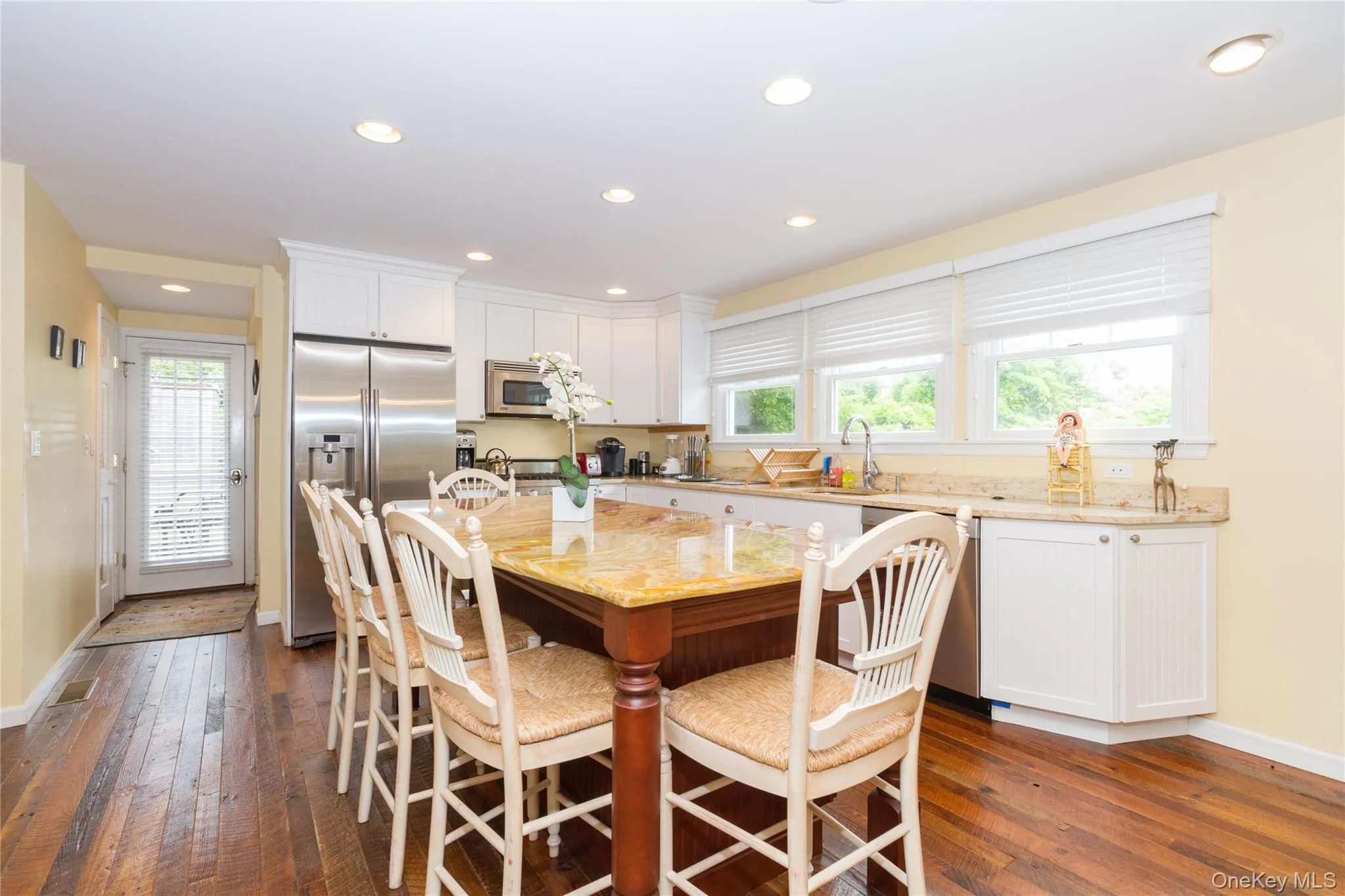 Dining room with dark wood-style floors and recessed lighting Dining room with dark wood-style floors and recessed lighting