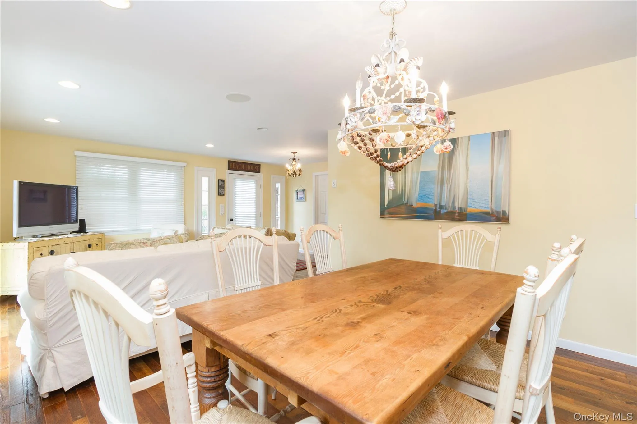 Dining room with dark wood-style flooring, a chandelier, and recessed lighting Dining room with dark wood-style flooring, a chandelier, and recessed lighting
