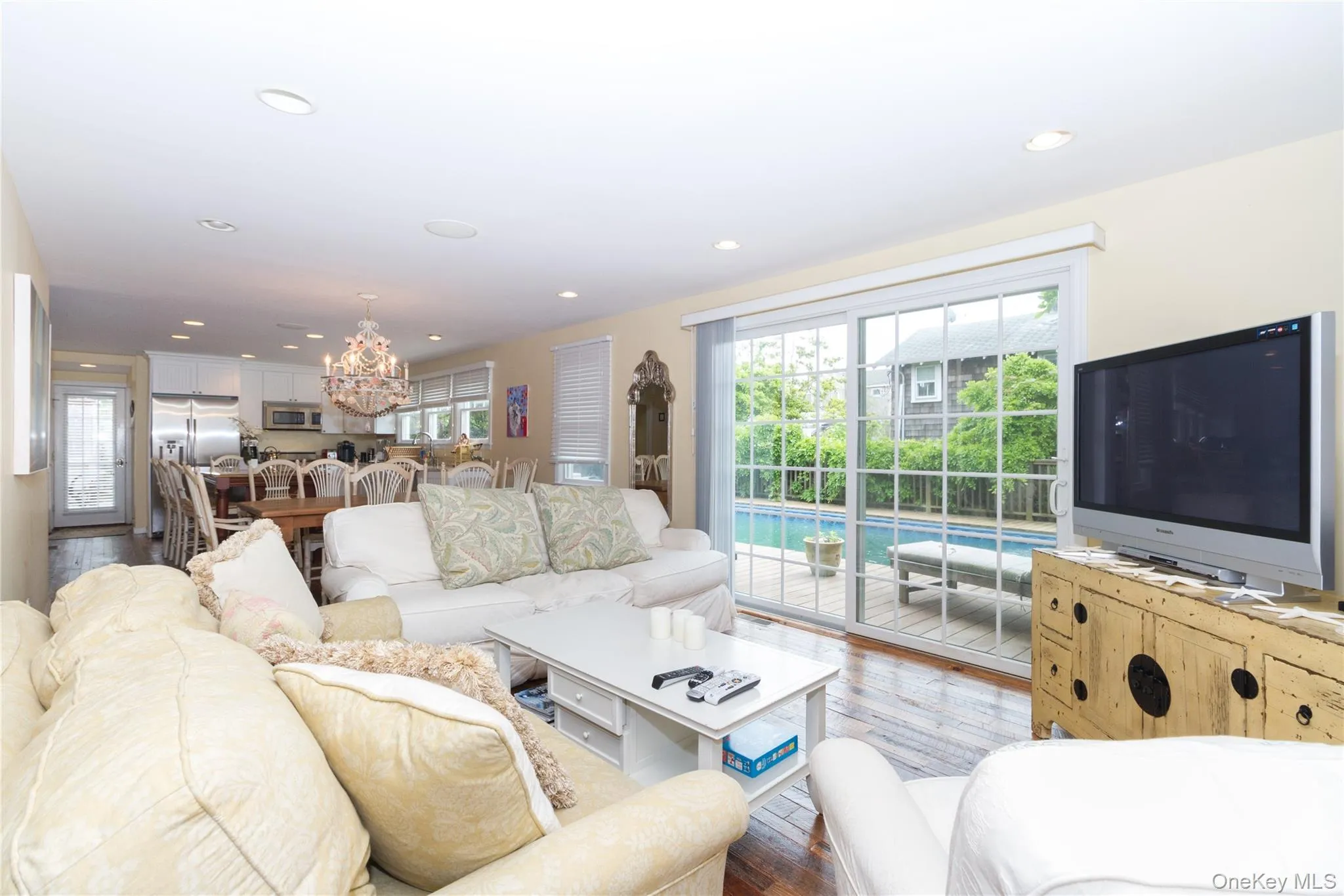 Living area featuring hardwood / wood-style floors, healthy amount of natural light, recessed lighting, and a chandelier Living area featuring hardwood / wood-style floors, healthy amount of natural light, recessed lighting, and a chandelier