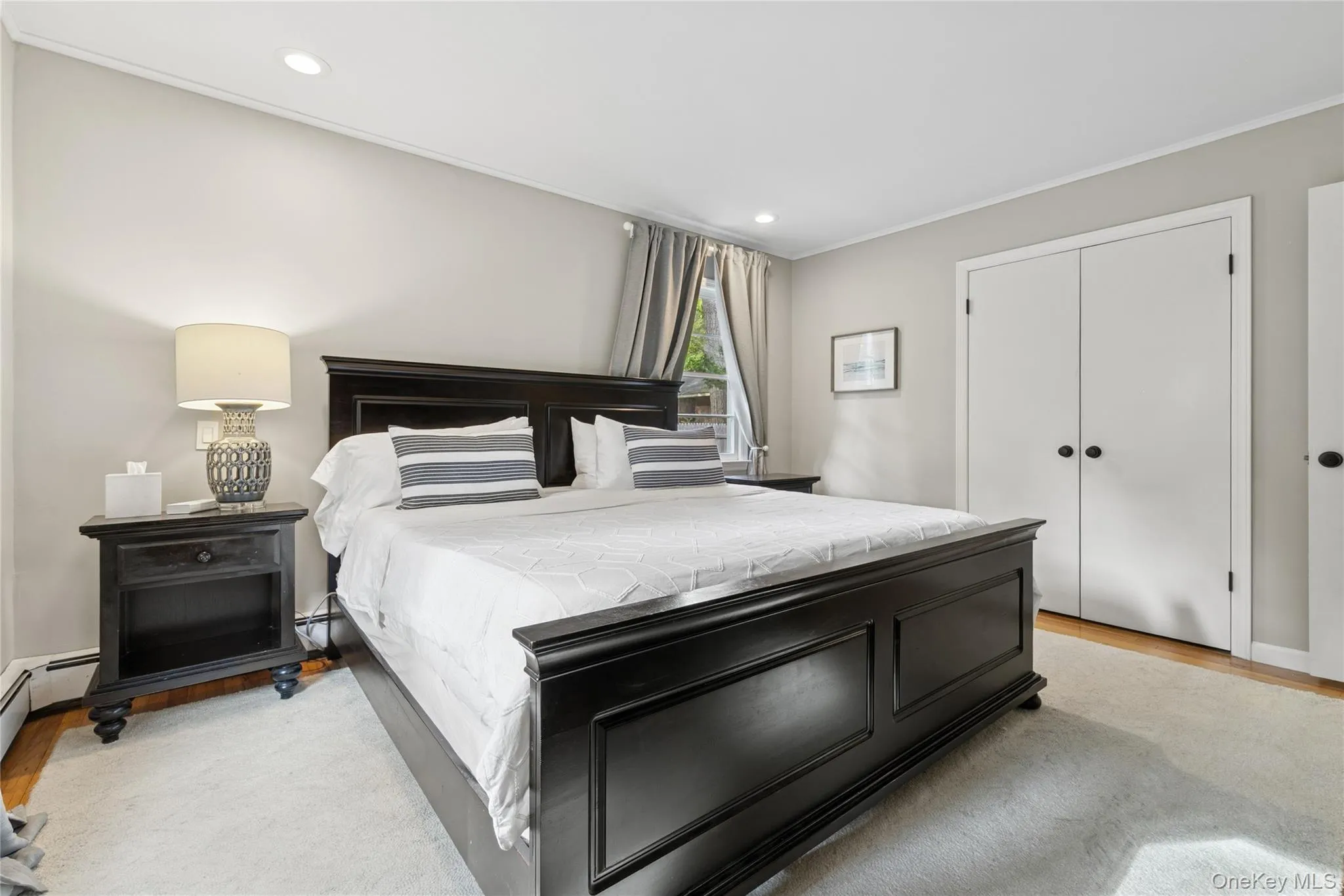Bedroom with light wood finished floors, recessed lighting, a closet, and ornamental molding Bedroom with light wood finished floors, recessed lighting, a closet, and ornamental molding