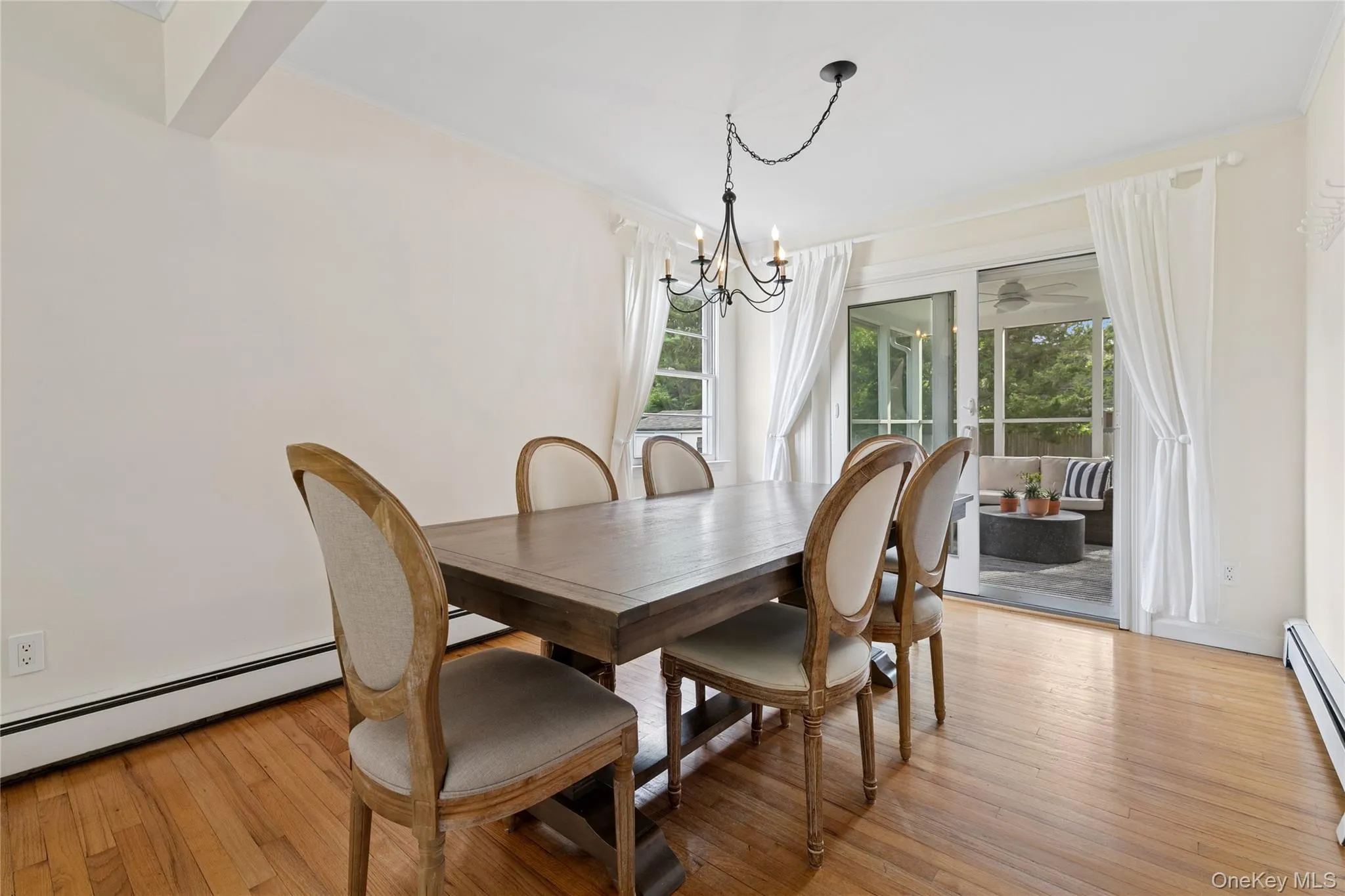 Dining room featuring light wood-style floors, healthy amount of natural light, and a chandelier Dining room featuring light wood-style floors, healthy amount of natural light, and a chandelier
