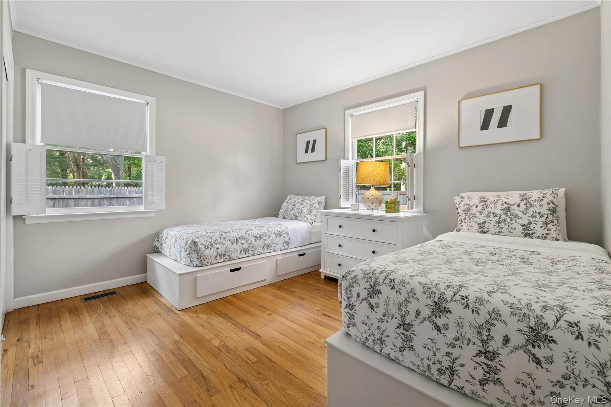 Bedroom featuring light wood-type flooring and ornamental molding Bedroom featuring light wood-type flooring and ornamental molding