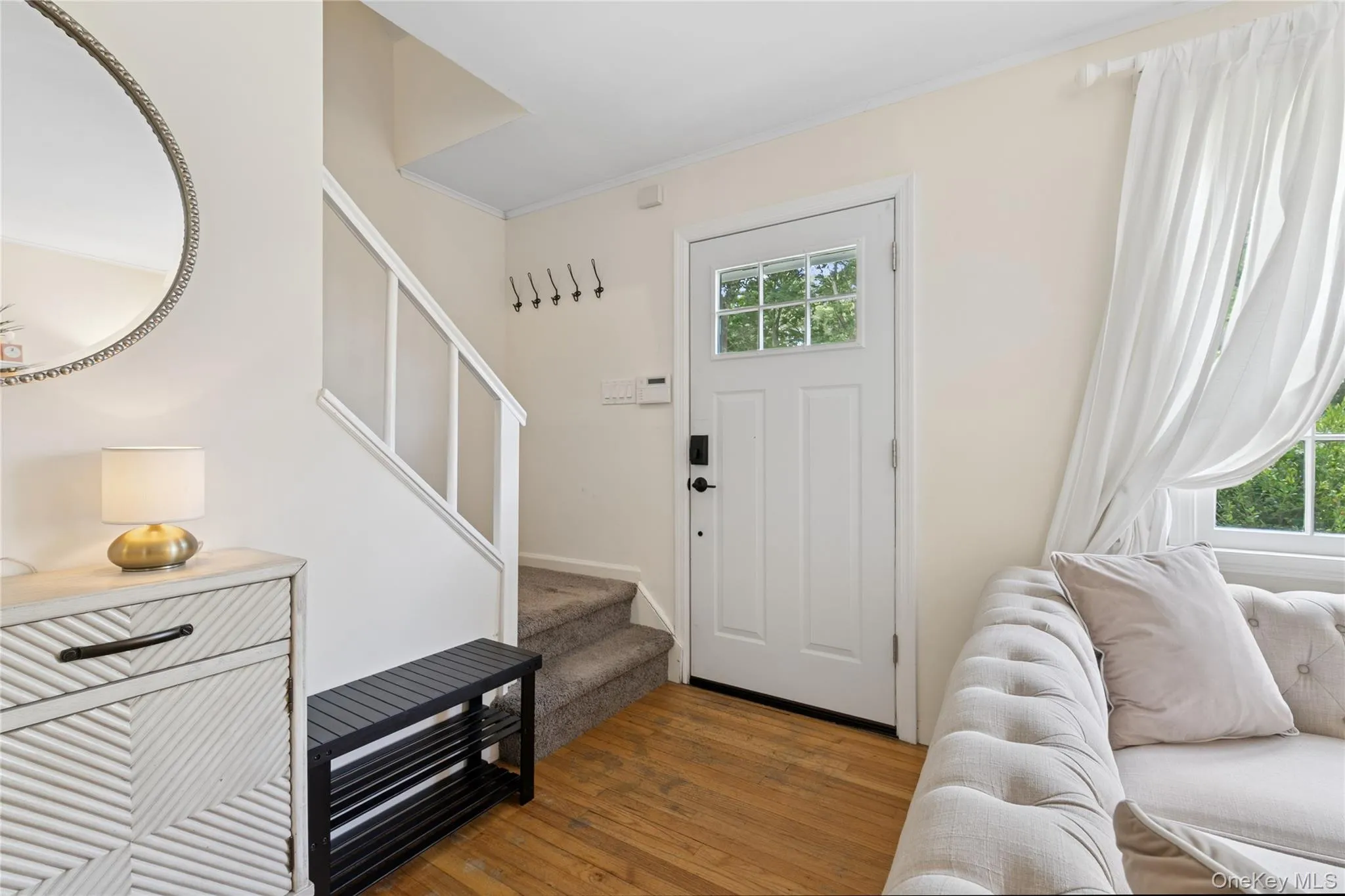 Foyer entrance featuring stairway, plenty of natural light, wood finished floors, and crown molding Foyer entrance featuring stairway, plenty of natural light, wood finished floors, and crown molding