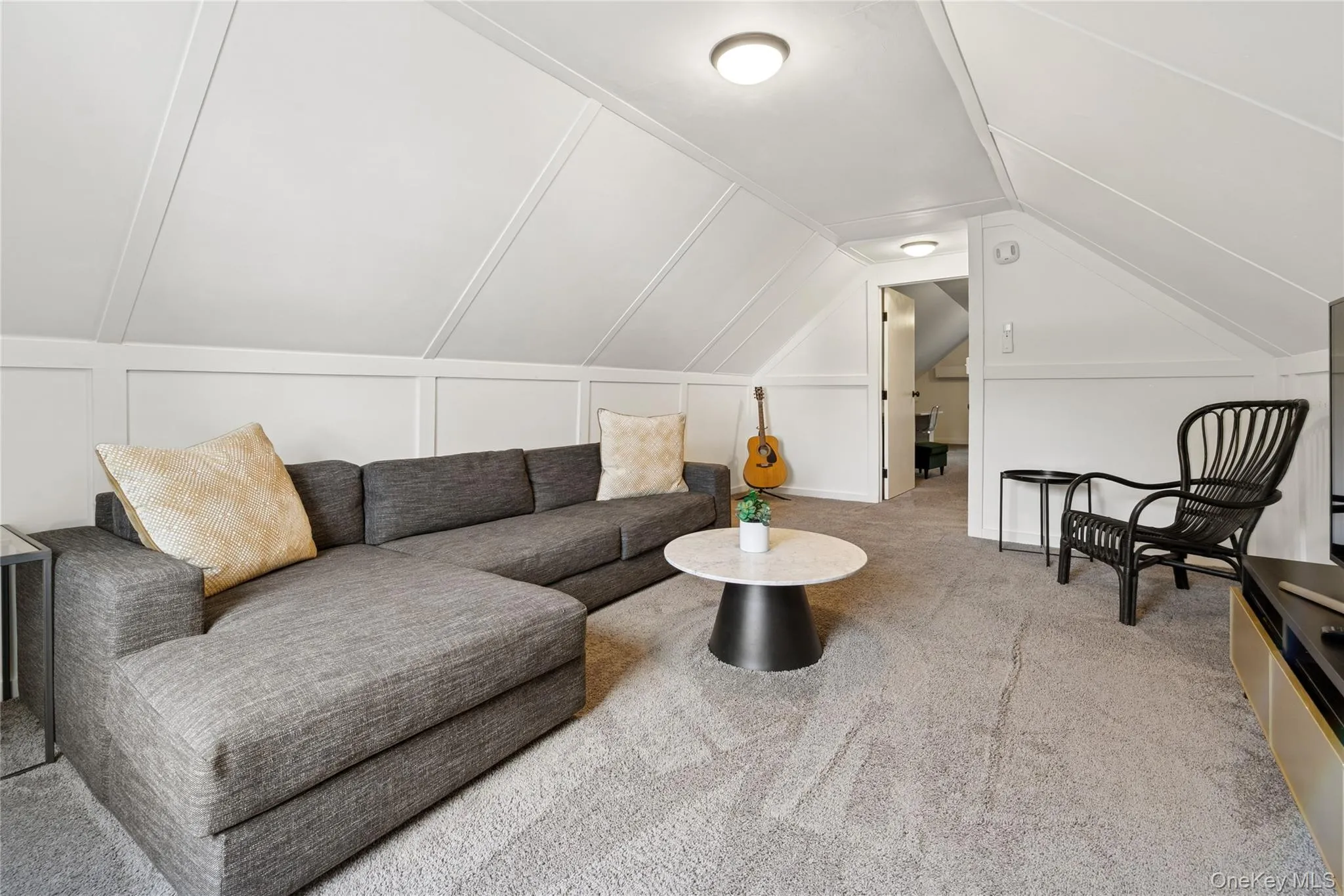 Living area with vaulted ceiling and carpet floors Living area with vaulted ceiling and carpet floors