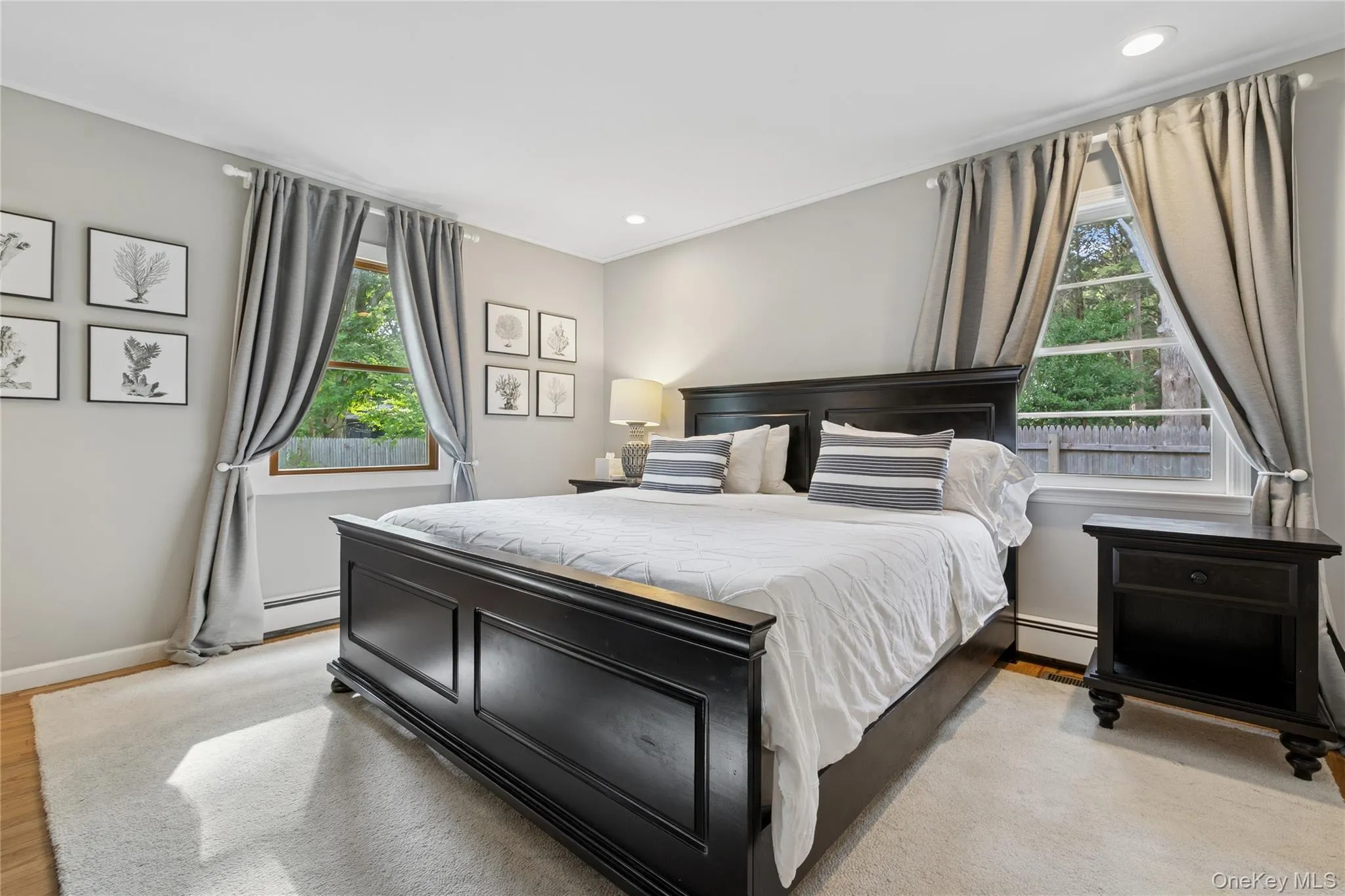 Bedroom with a baseboard heating unit, light wood finished floors, and recessed lighting Bedroom with a baseboard heating unit, light wood finished floors, and recessed lighting