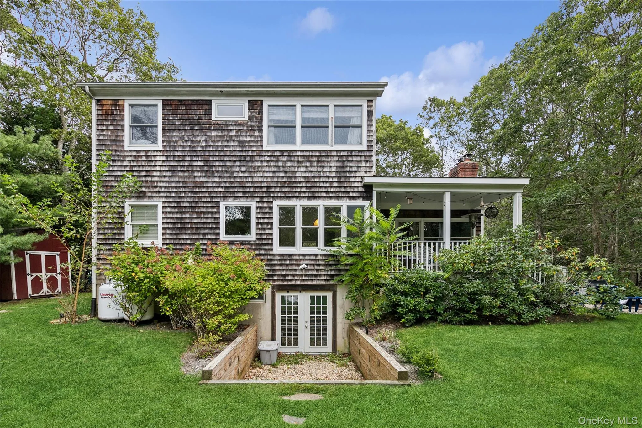Back of property featuring a lawn, a shed, french doors, and a chimney Back of property featuring a lawn, a shed, french doors, and a chimney