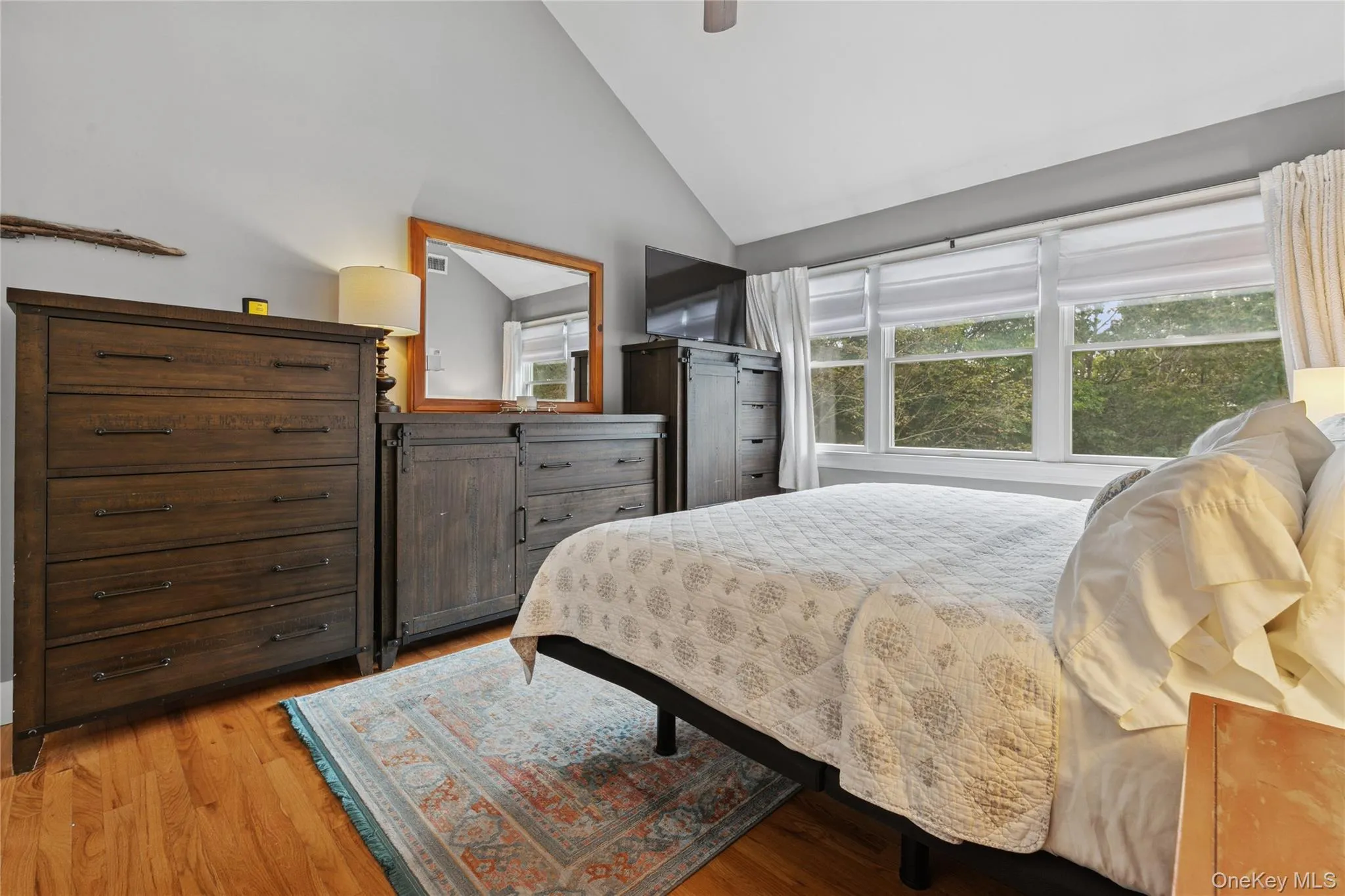 Bedroom with light wood-style flooring, ceiling fan, and high vaulted ceiling Bedroom with light wood-style flooring, ceiling fan, and high vaulted ceiling