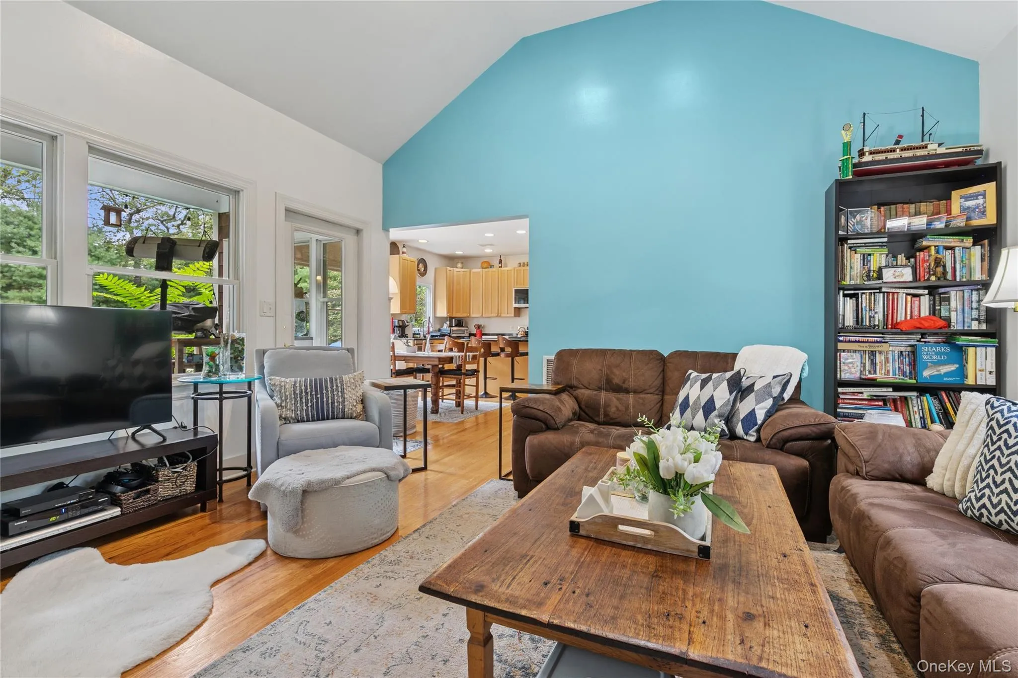 Living room with wood finished floors and high vaulted ceiling Living room with wood finished floors and high vaulted ceiling