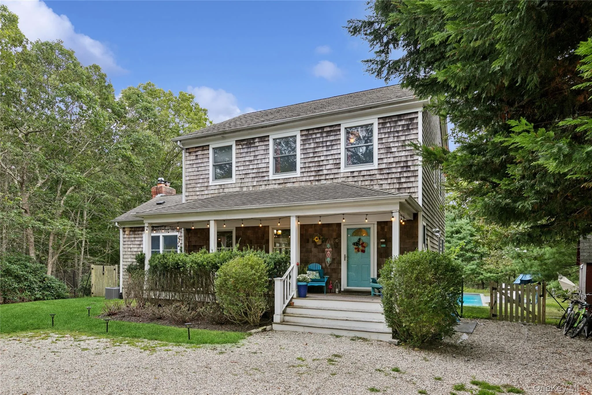 View of front of property featuring a porch, a shingled roof, and a chimney View of front of property featuring a porch, a shingled roof, and a chimney