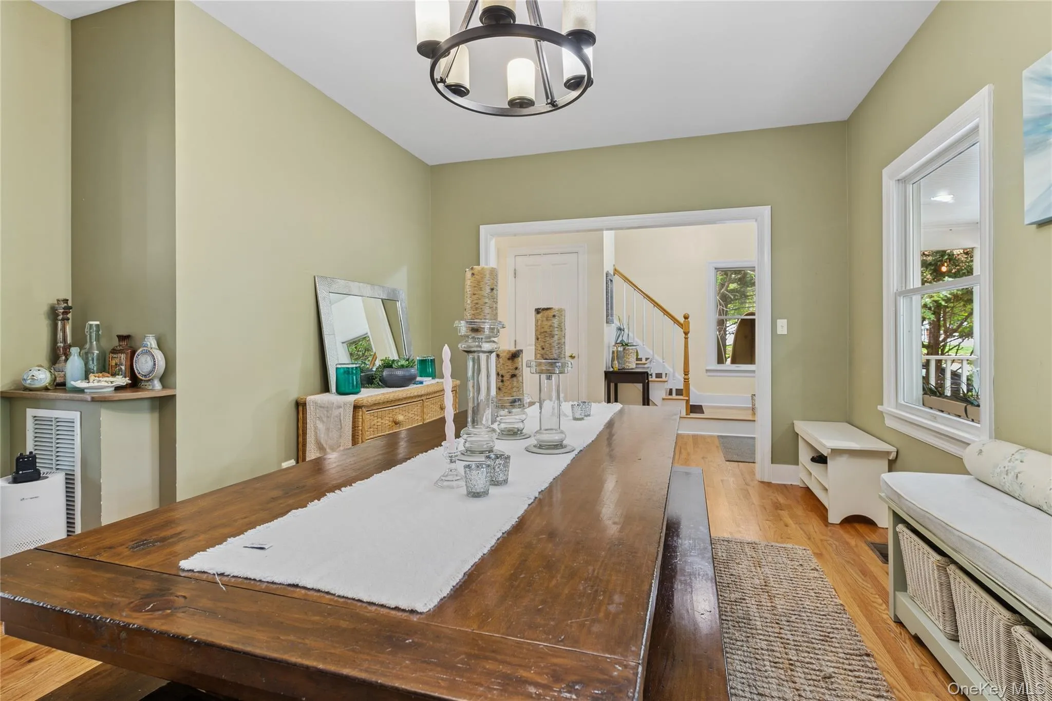 Dining space featuring light wood-type flooring, a chandelier, and stairs Dining space featuring light wood-type flooring, a chandelier, and stairs