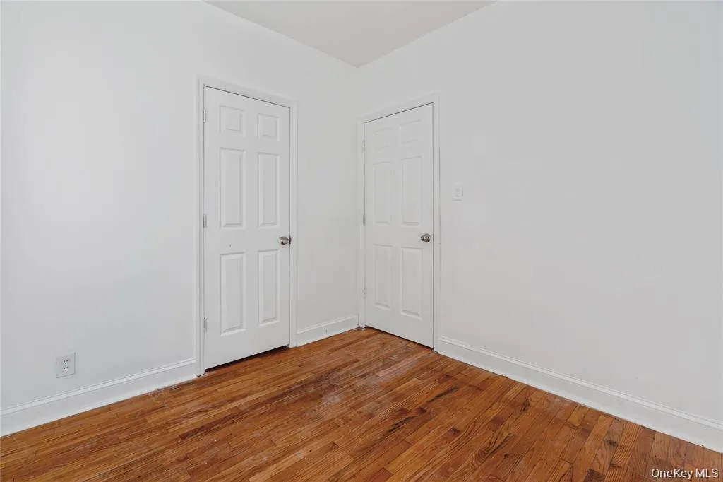 Spare room with baseboards and wood finished floors Spare room with baseboards and wood finished floors
