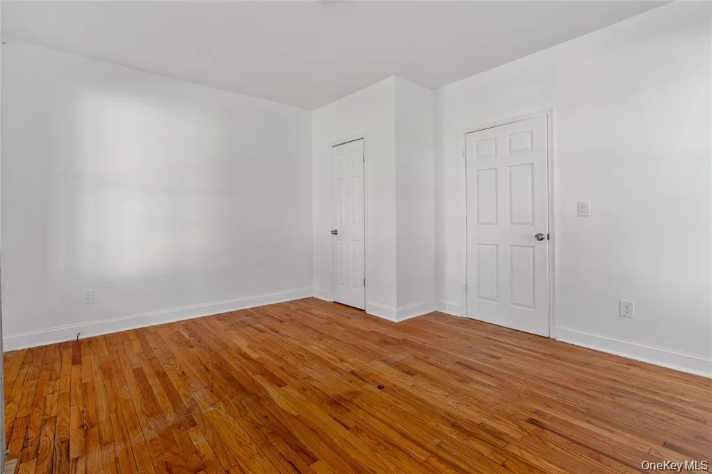 Spare room with light wood-type flooring and baseboards Spare room with light wood-type flooring and baseboards