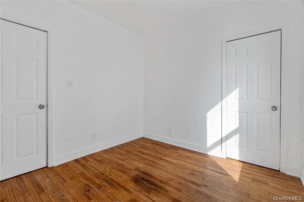Spare room with baseboards and wood-type flooring Spare room with baseboards and wood-type flooring