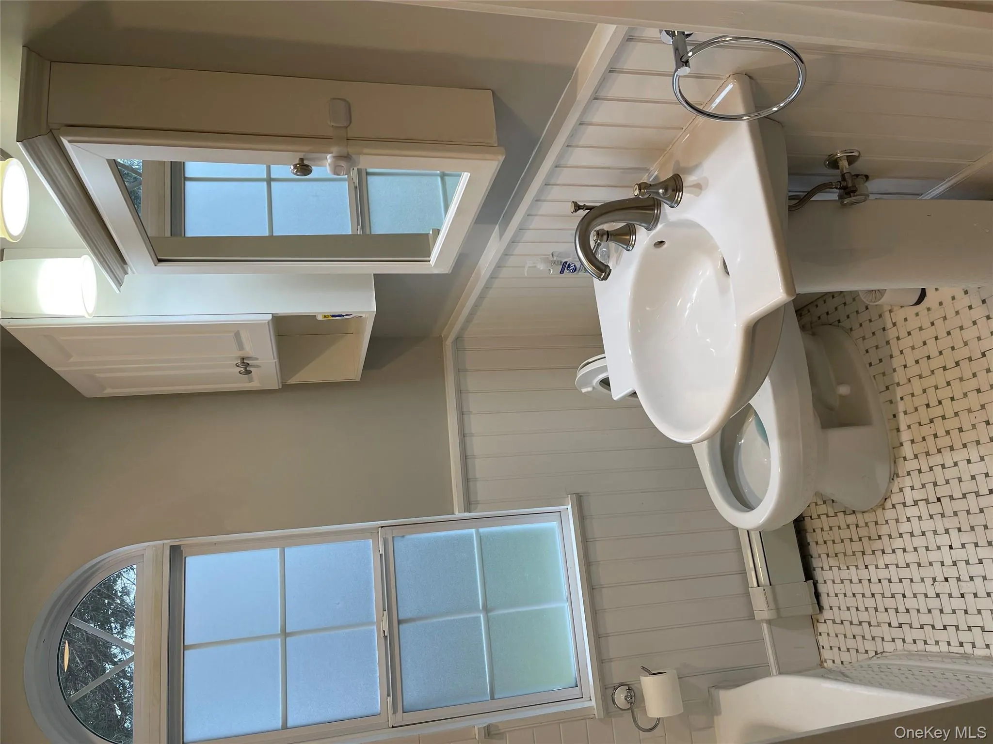 Full bath with wainscoting, baseboard heating, healthy amount of natural light, and a bathtub Full bath with wainscoting, baseboard heating, healthy amount of natural light, and a bathtub