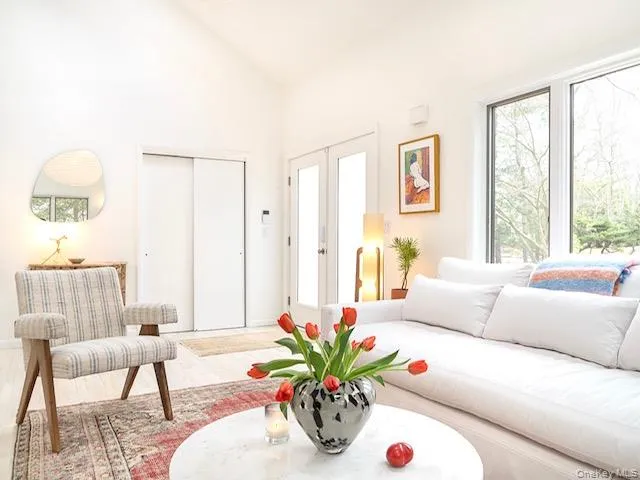 Living area with wood finished floors, french doors, and high vaulted ceiling Living area with wood finished floors, french doors, and high vaulted ceiling
