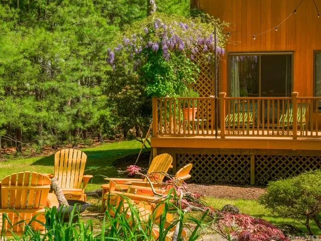 View of green lawn with a wooden deck View of green lawn with a wooden deck