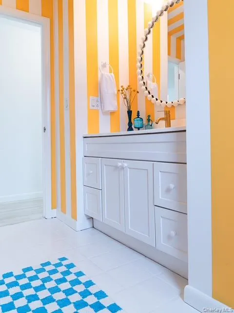 Bathroom featuring vanity and wallpapered walls Bathroom featuring vanity and wallpapered walls