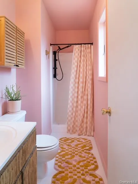 Bathroom featuring a stall shower, vanity, and light tile patterned floors Bathroom featuring a stall shower, vanity, and light tile patterned floors