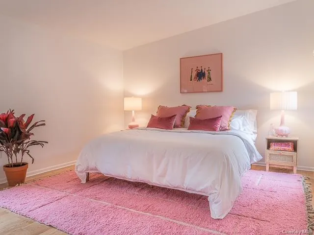 Bedroom featuring wood finished floors and baseboards Bedroom featuring wood finished floors and baseboards